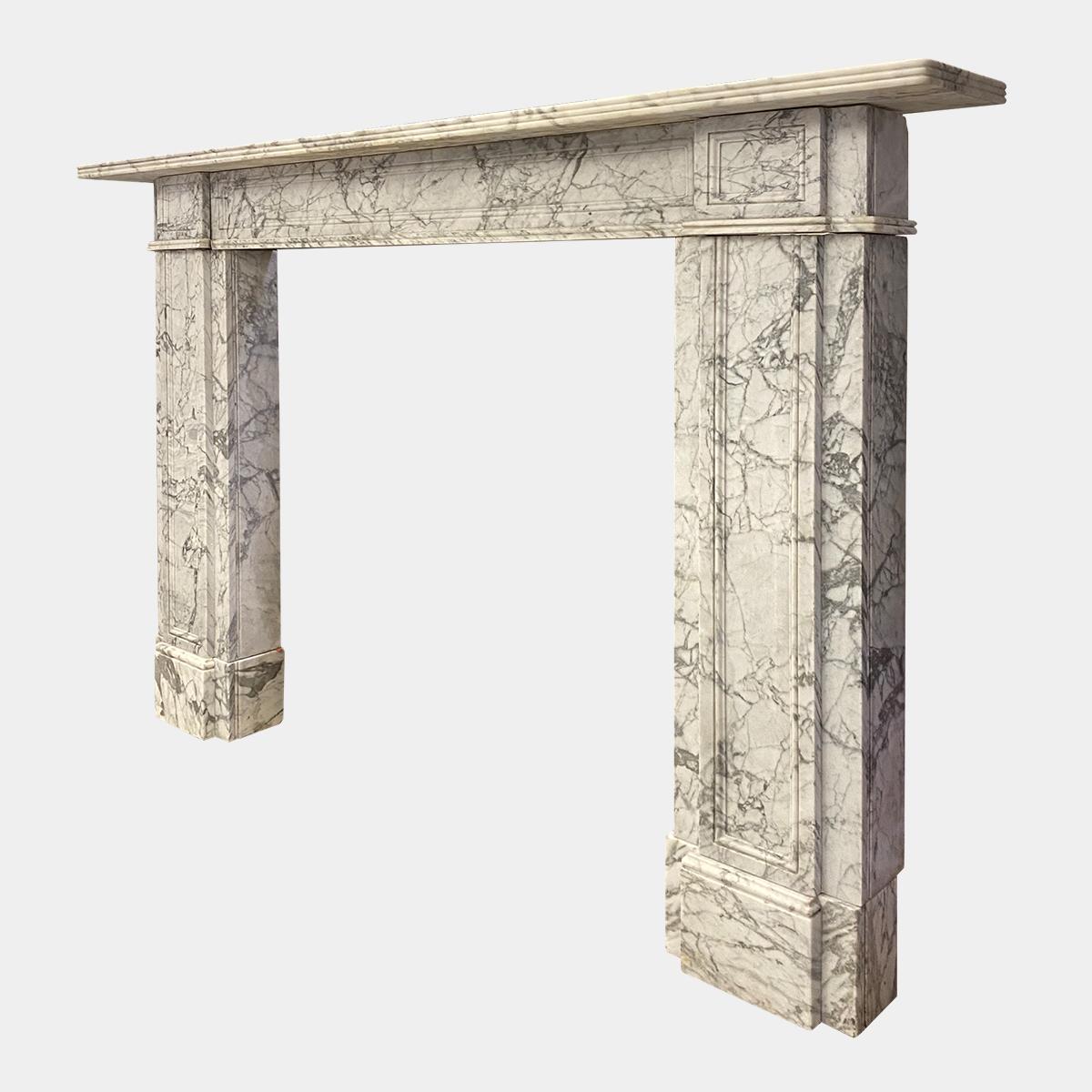 A large variegated marble surround from the early 19th century. Architectural in design, with fielded paneled jambs and frieze. Supported on square foot blocks. The conforming paneled end blocks with paneled frieze between. The mouldings matching