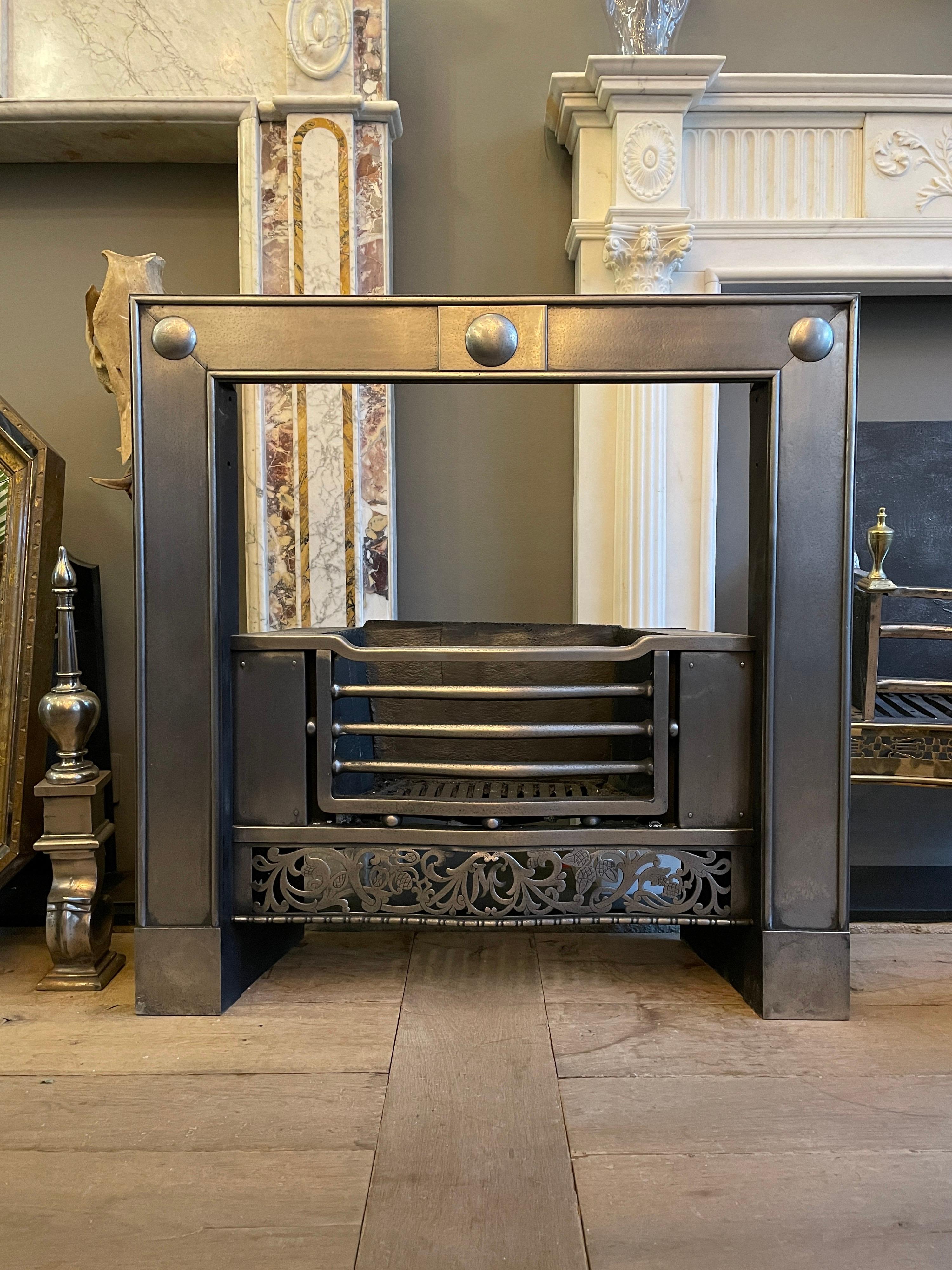 A Georgian style register grate in polished steel. The shaped bars with spherical spacers, flanked by plain panels with a finely cut fret beneath of scrolled foliage and strung bead edge. The outer panels with edged border and three raised roundels.