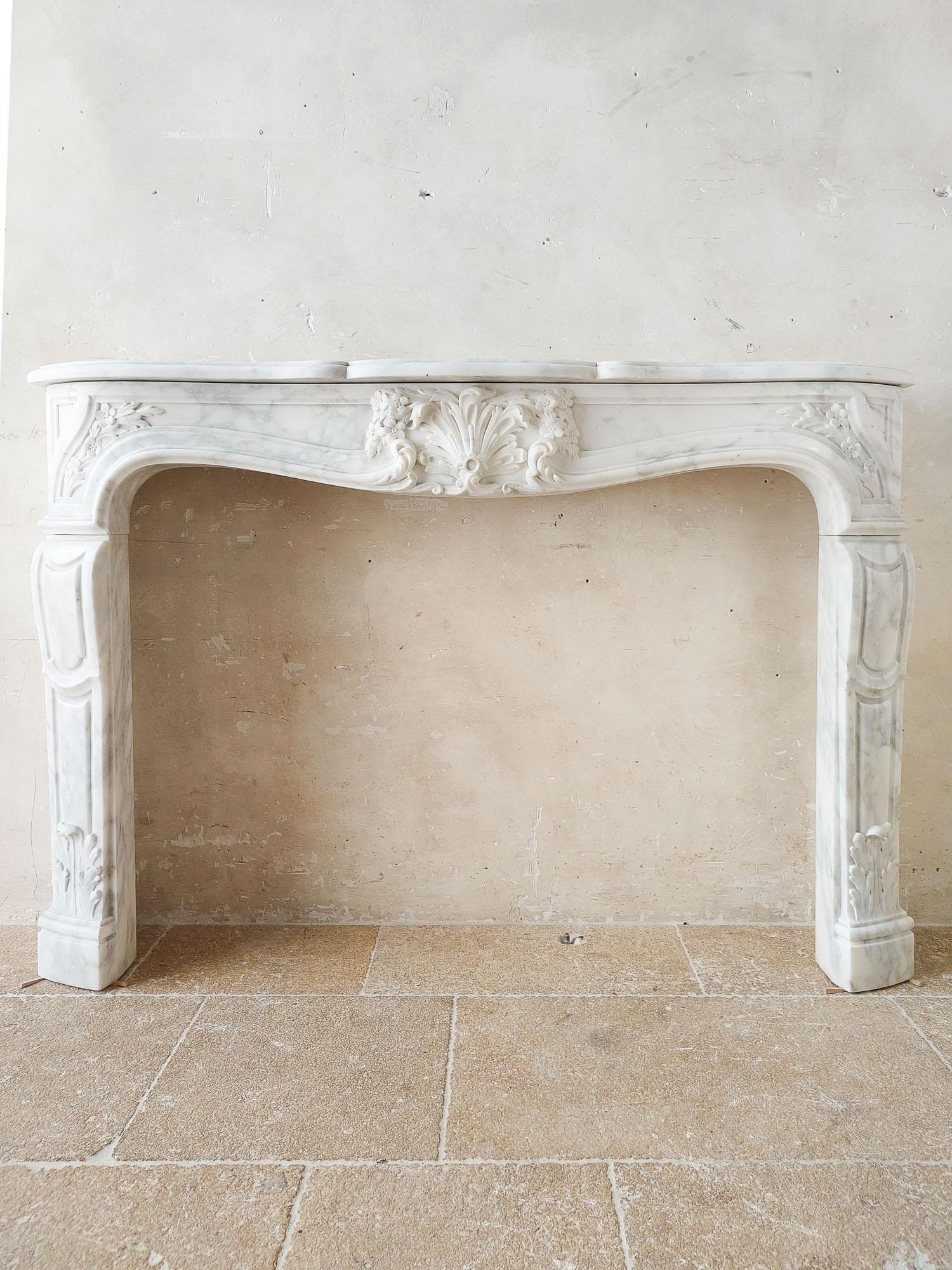 Antique French Carrara marble coquilles fireplace, beautiful richly carved shell ornament in the middle, with fine flower decorations on both sides and acanthus leaves on the jambs.

dimensions: h 104 x w 150 x d 30 cm
opening: 86 x 120 cm