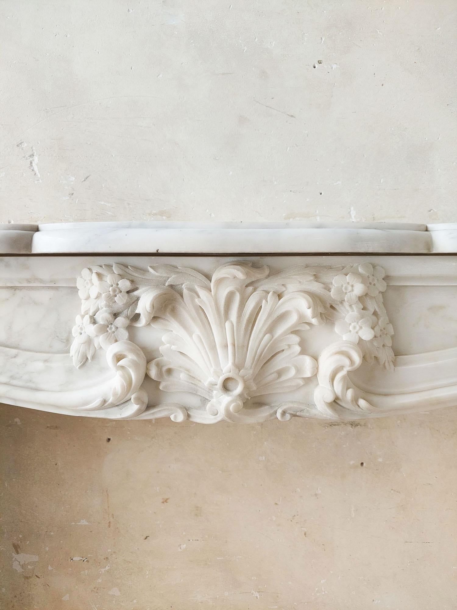 An Antique French Beautifully Carved Carrara Marble Fireplace with Coquille In Good Condition For Sale In Baambrugge, NL