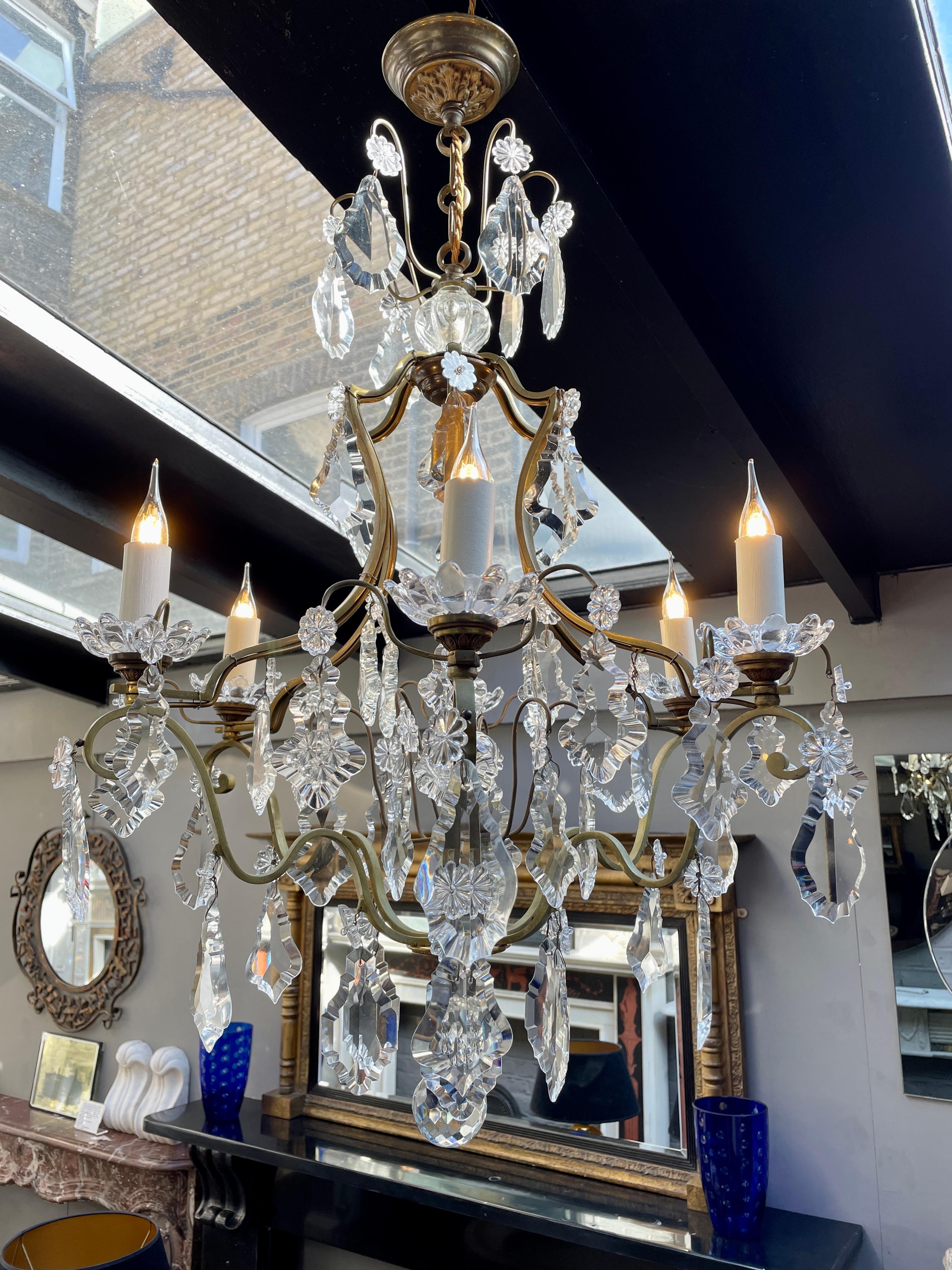 A late 19th century brass cage chandelier with crystal drops and prism to centre. A faceted crystal ball drop to bottom. the drops faceted and feathered. This light has been completely rewired along the frame and the fittings and is in very good