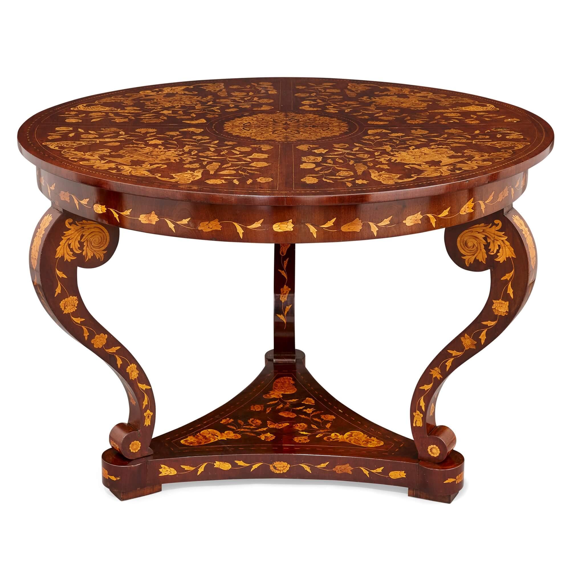 An antique French circular marquetry table with floral inlay
French, early 20th century
Measures: Height 76cm, diameter 108cm

This fine antique table features an extensive, bright marquetry decorative design that adorns each face and surface,