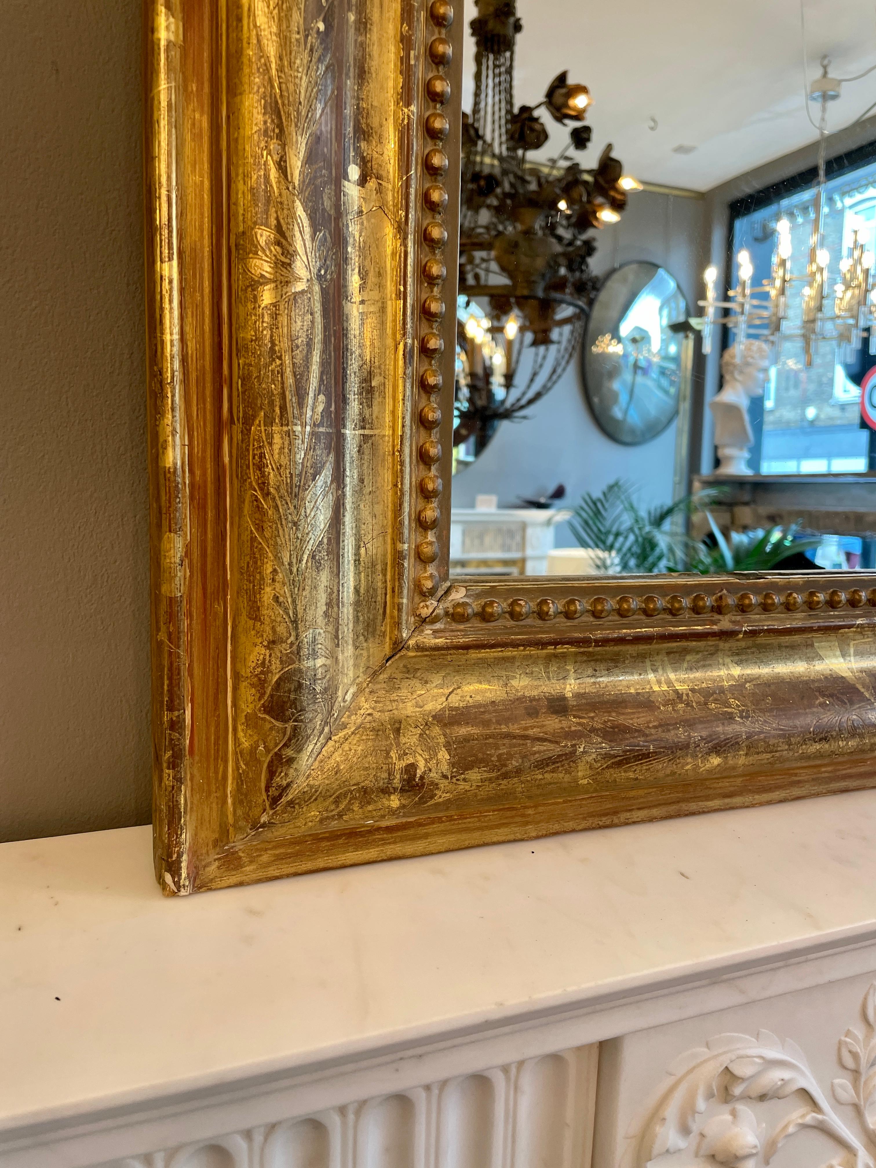 A Mid 19th century Louis Philippe style mirror, with original plate, floral gilt work to frame and beaded mirror border.