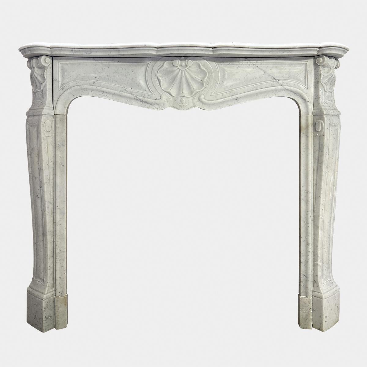 An attractive Louis XV style 3 shell Carrara marble fireplace from the mid 19th century. The panelled legs with carved shell end blocks, the serpentine frieze again panelled with central carved shell cartouche. All beneath a deep serpentine shelf,