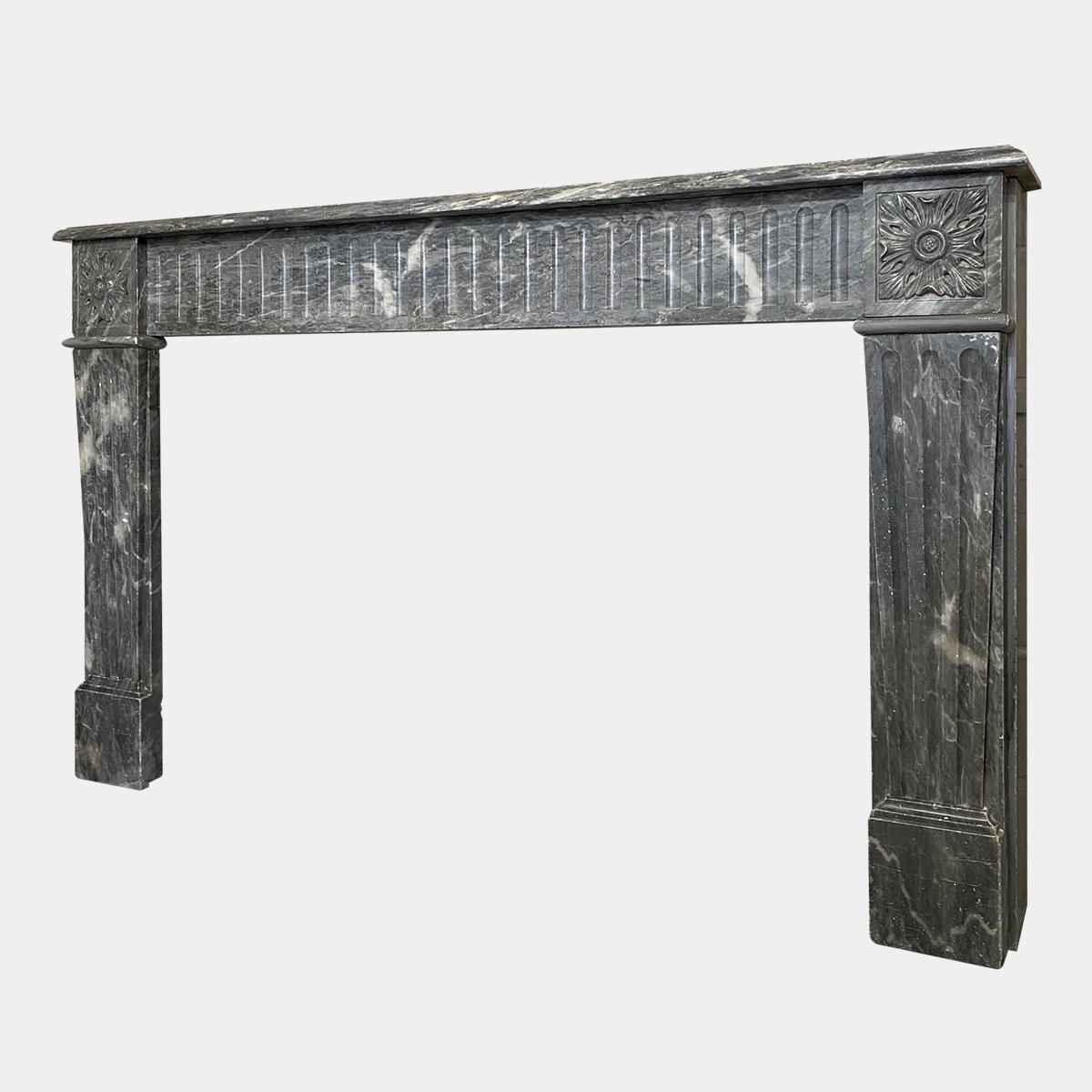 A very large and substantial Louis XVI period fire surround from the late 18th century. The wide fluted frieze with end blocks of large well carved square Patarae, supported by conforming and tapering fluted front panels. All beneath a wide a