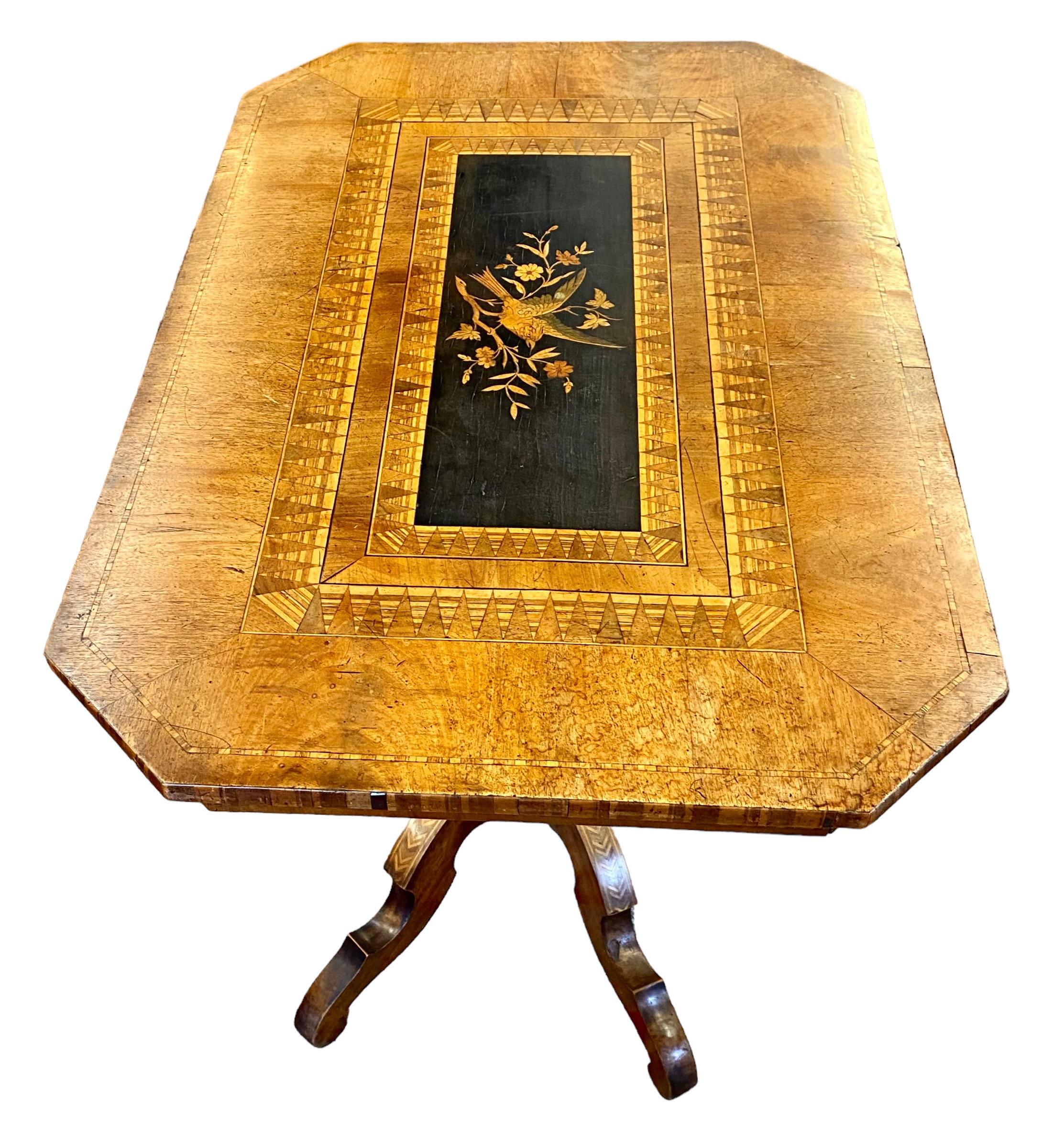 A stunning French marquetry and parquetry inlaid walnut side table, circa 1880, with a center rectangular bird and floral inlaid marquetry panel, flanked by a parquetry inlaid canted top, on a large inlaid turned support, to four inlaid cabriole