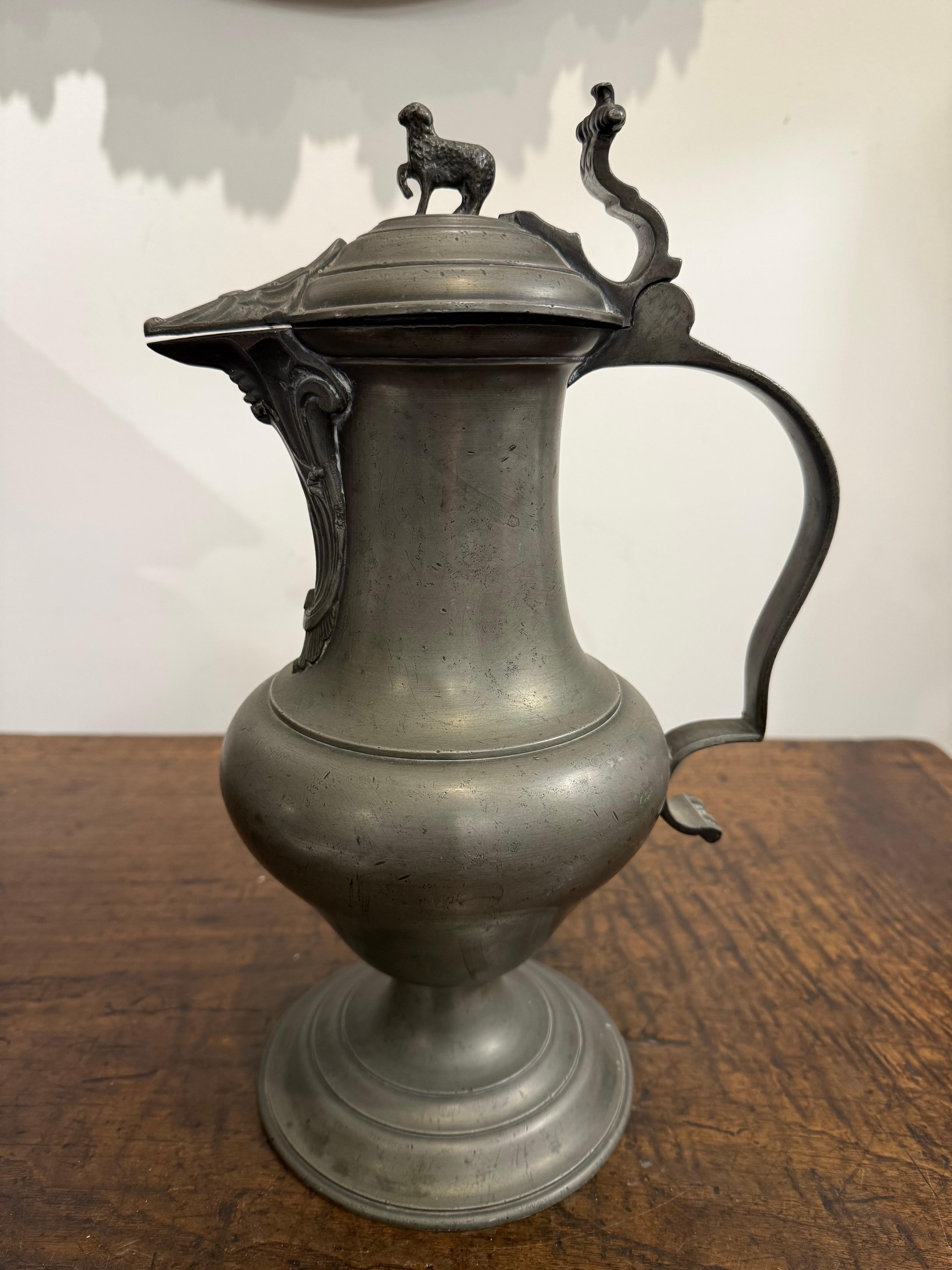 Antico vaso tedesco in peltro inciso, XVIII secolo

Descrizione:
La brocca ha un design con coperchio e il coperchio è ornato da un elemento figurato di un agnello, che ne aumenta il fascino decorativo. 

Provenienza:
Collezione privata