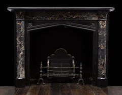 An antique Gothic revival, black marble and portoro marble mantel