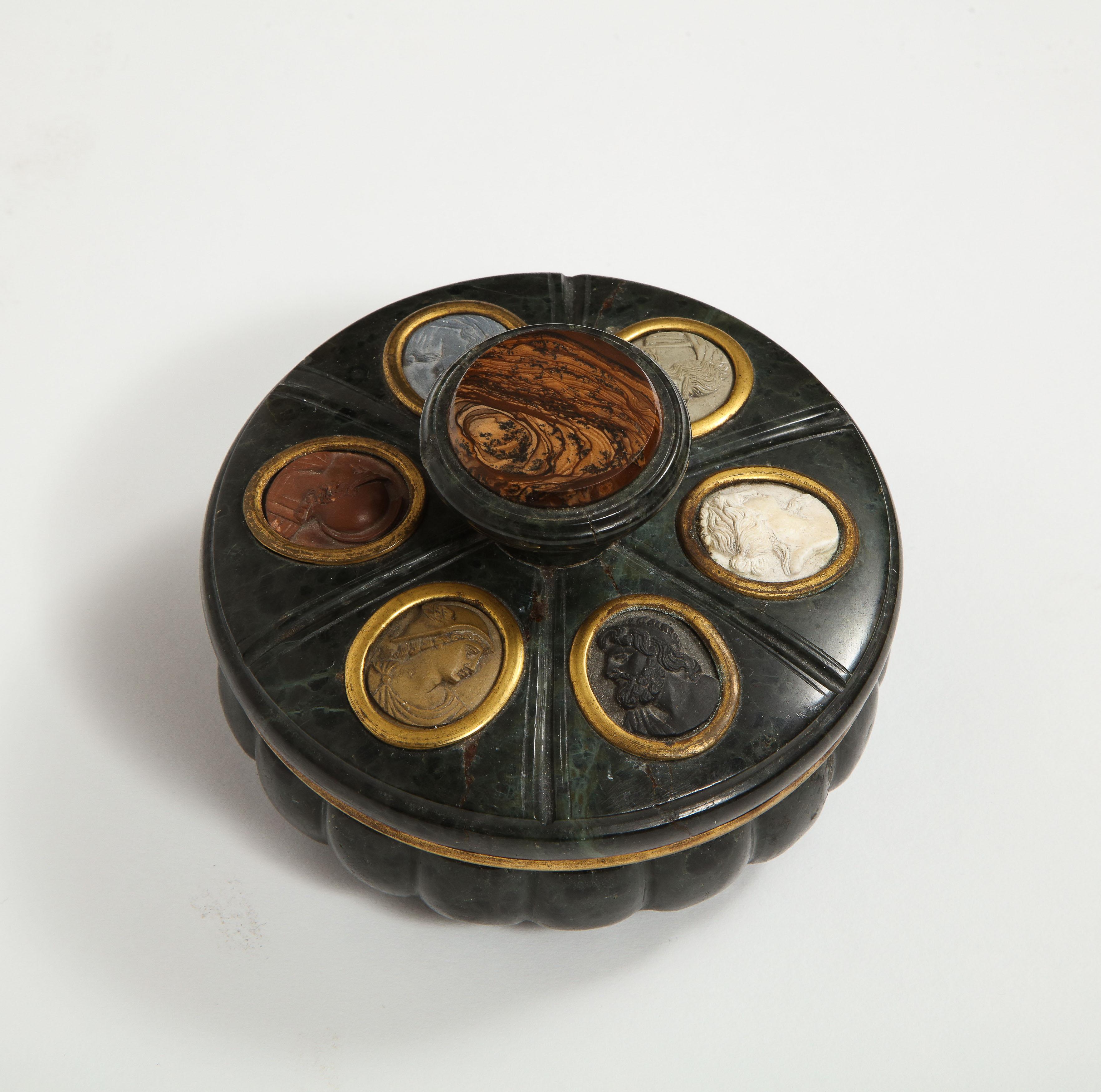 An antique Italian Grand Tour green Serpentine marble Inkwell, Naples, Italy, circa 1860.

A round marble inkwell, the lid exterior set with lava cameos of Classical figures, the interior with a watercolor scene.

Very nice and collectible