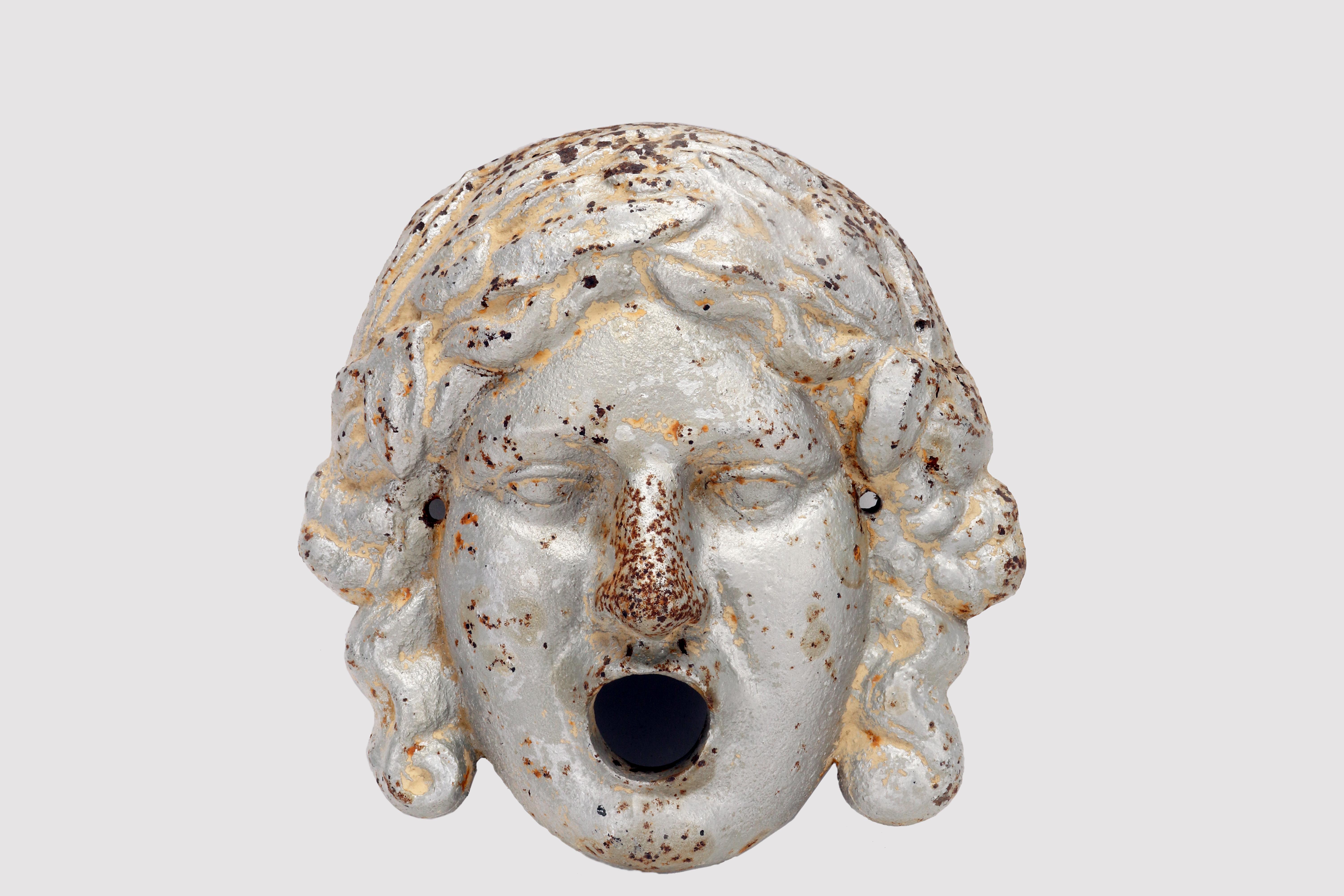An antique Italian woman face from a garden fountain, made out of heavy painted cast iron with a rich originally patina. Italy late 19th century.