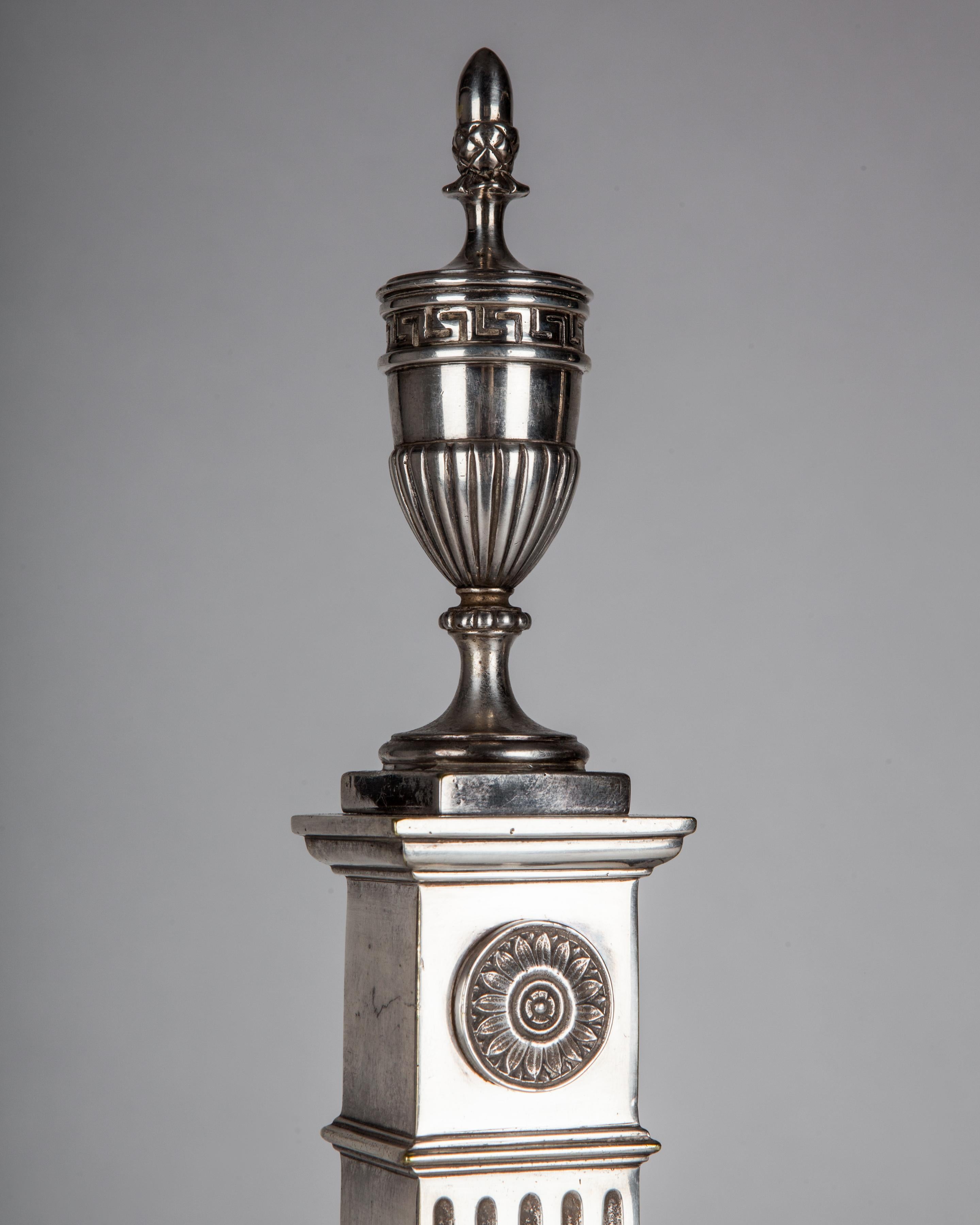 Noirci Chenets néoclassiques en métal argenté avec colonnes cannelées et fleurons en forme d'urne, vers les années 1910 en vente