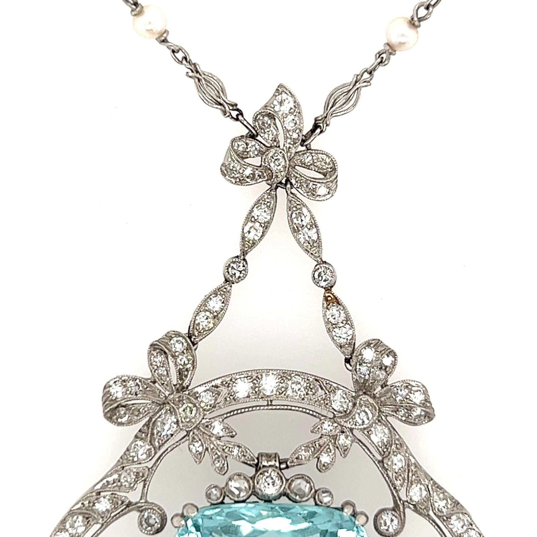 An antique platinum, aquamarine, pearl and diamond necklace, circa 1915.  The lavaliere designed as a ribbon form set with approximately thirty eight (38) old European cut diamonds suspending an open quatrefoil set with approximately fifty eight