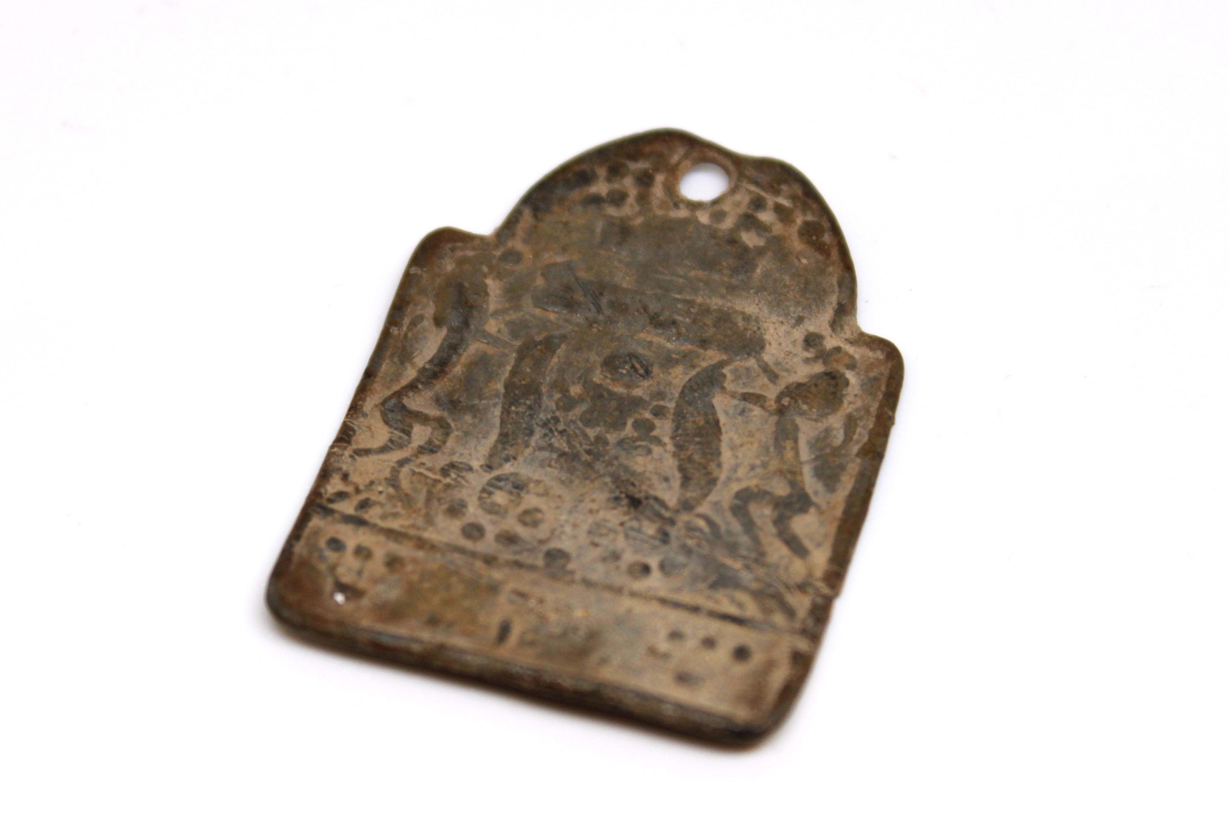 Cette intrigante amulette ancienne en plomb, découverte en Pologne après des décennies passées sous terre, porte les marques mystérieuses de son long enfouissement, la plupart de ses motifs originaux étant aujourd'hui adoucis et estompés par le