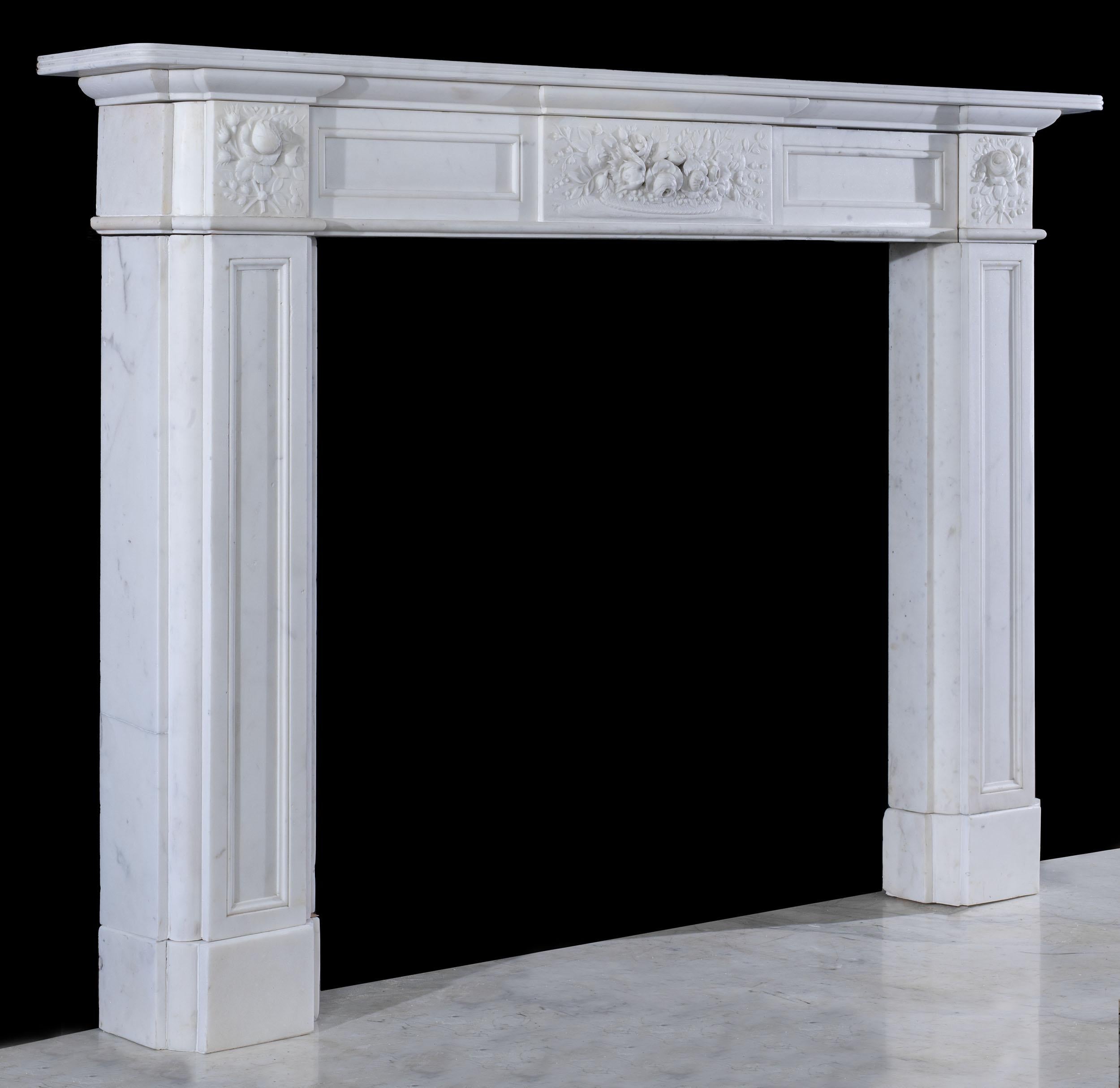 A beautifully carved early Victorian fireplace in pure white statuary marble. The plain shelf sits above a panelled frieze which is centred by a delicately carved tablet which is profusely carved with a basket of flowers in high relief. This is
