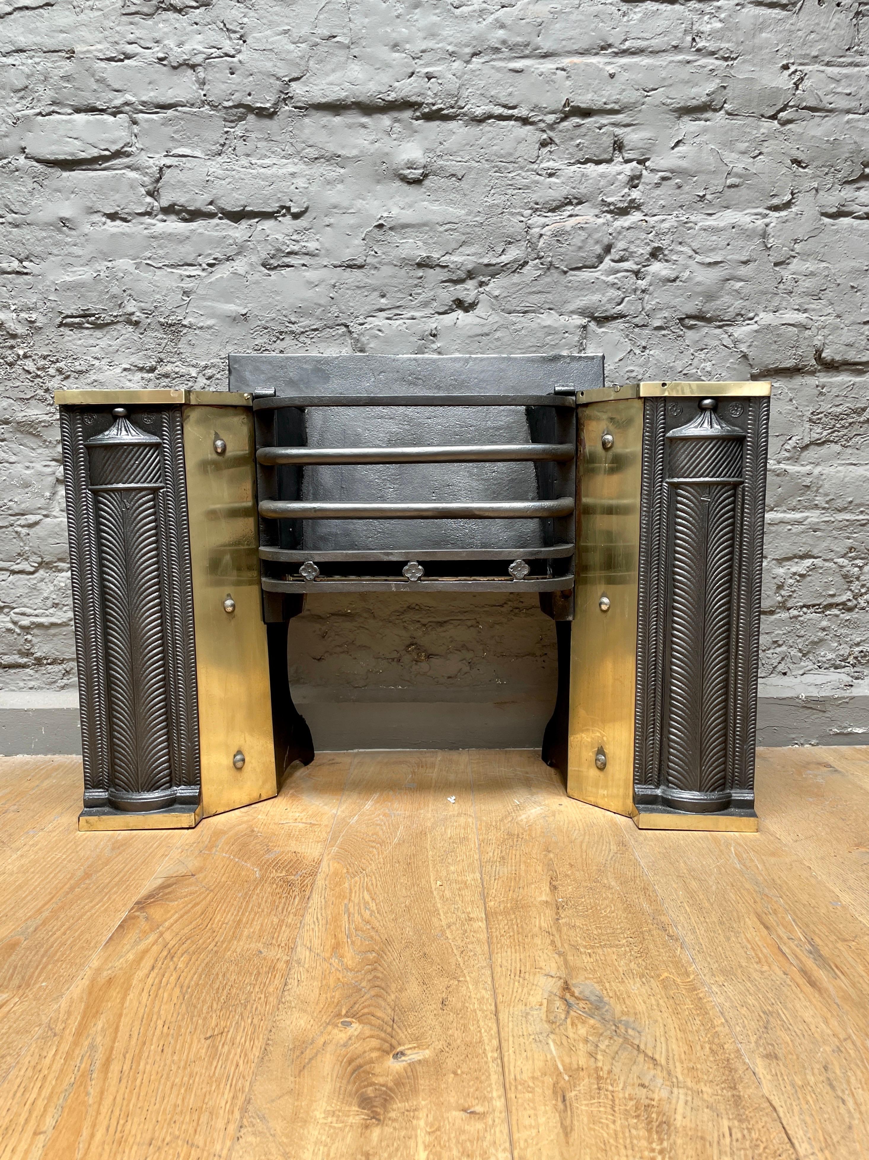 A large and substantial half hob grate in cast iron with brass reflector plates and embellishments. The pillared front panels flanking a bowed bar burning area, which will be enhanced when lit by the polished brass reflector plates. A good quality