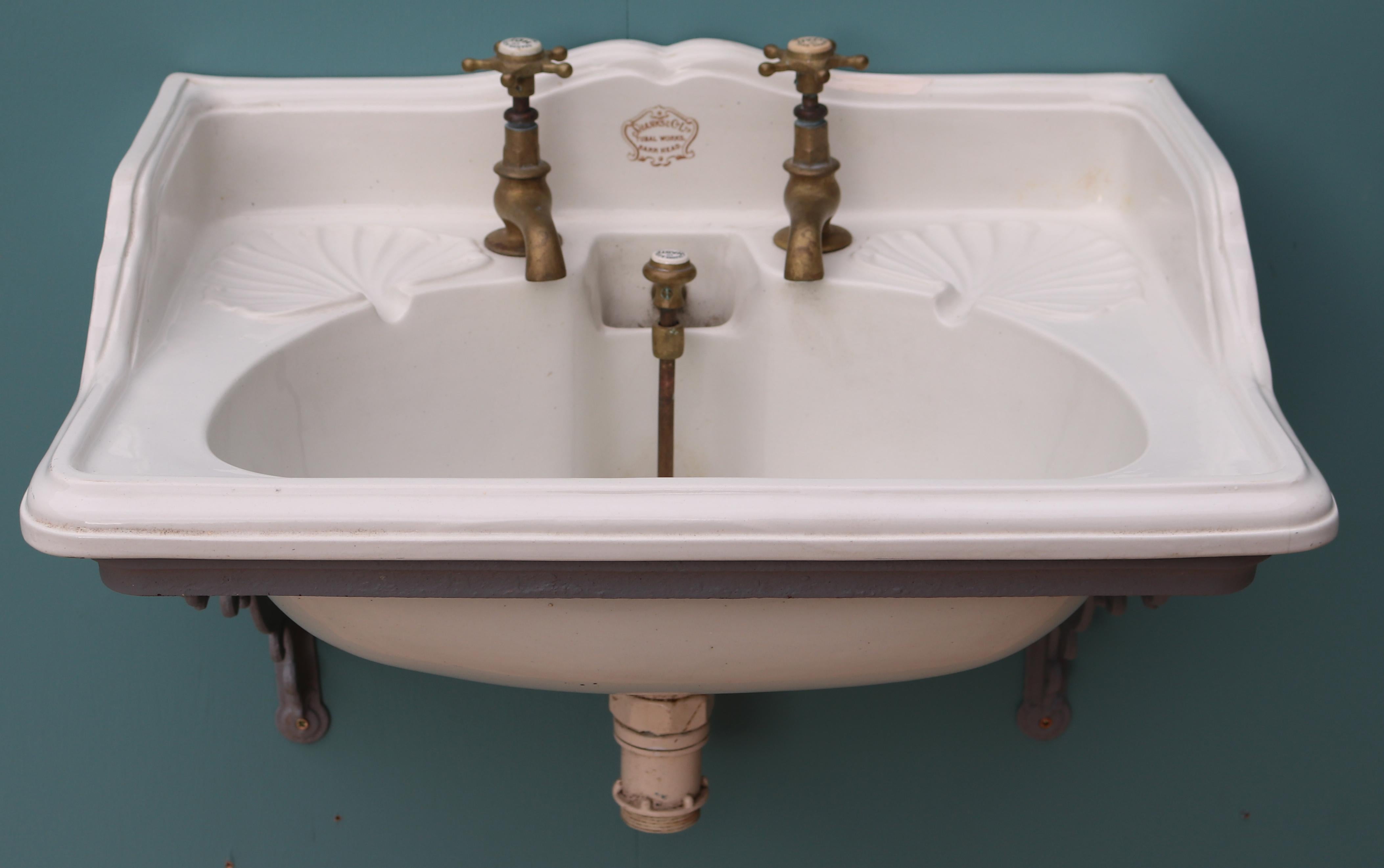 A Shanks plunger basin with original brass taps and waste. Sitting on a wall-mounted iron bracket, finished in grey primer.

Condition report:

Good structural condition. Small hairline crack in the bowl. This has been tested and does not leak.
