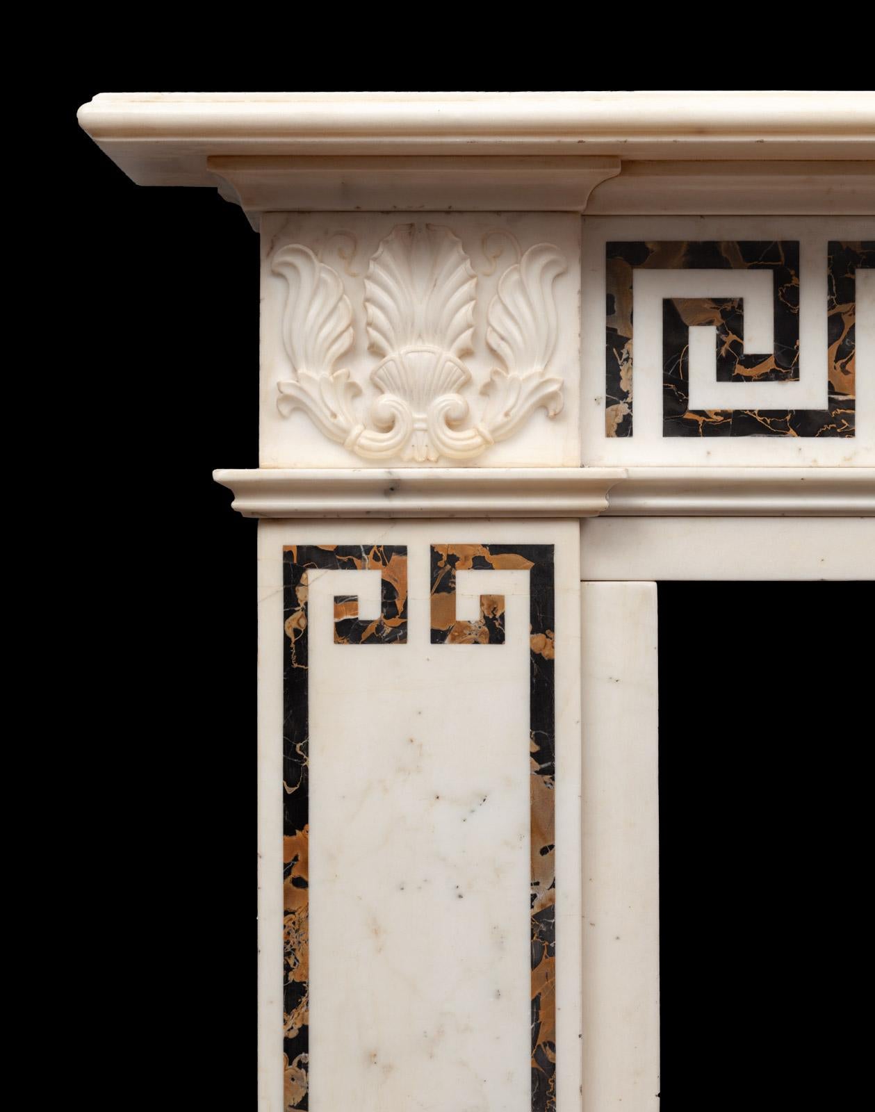 An antique Statuary and Portoro marble fireplace in the English Regency Greek revival style

The white statuary marble corner blocks carved with stylised lotus and acanthus leafs. The frieze panel inlaid with black and gold ‘Portoro Nero’ marble