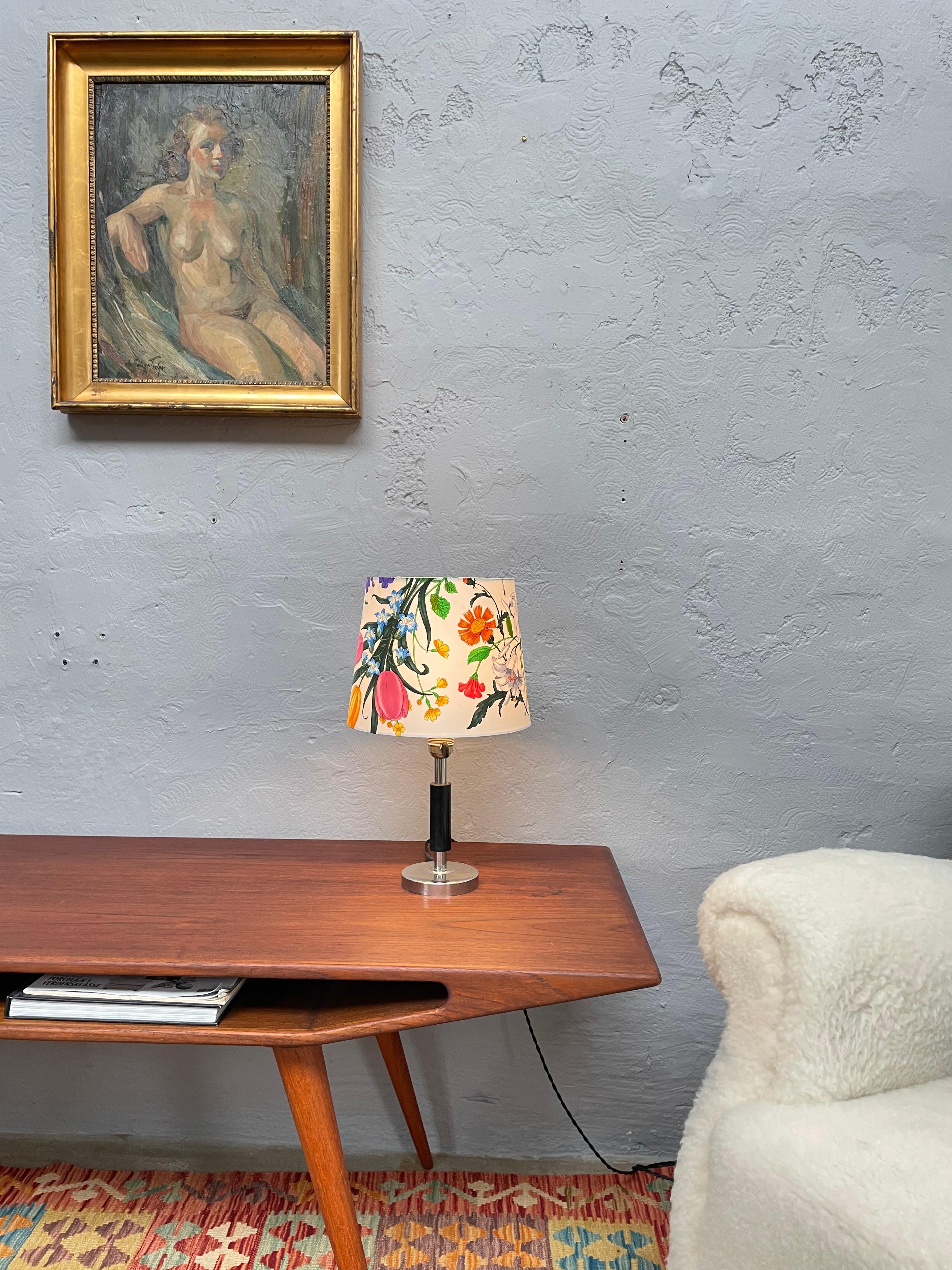 An antique Swedish art deco table lamp of a diminutive size standing 40cm tall and with an adjustable lamp shade holder in brass and plastic most probably fitted in the mid century. 
Weighted with a cast iron base and fitted with a nickel platted