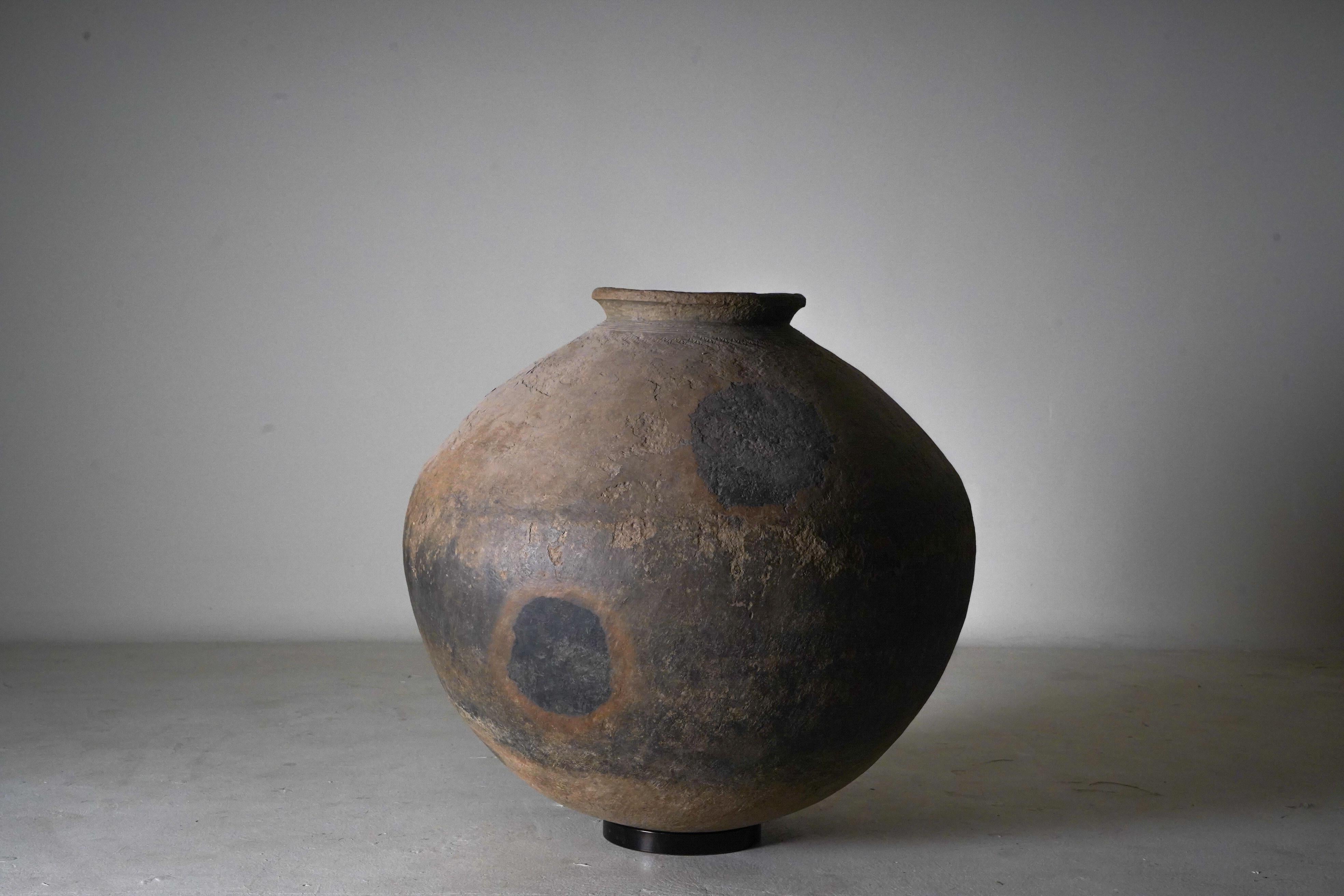A large and rare terracotta vessel from the Mon people of the Irrawaddy River valley, Burma. These huge vessels were fired in stacked groupings. Where the jars directly touched one another, the grey terra cotta turned black due to lack of oxygen.