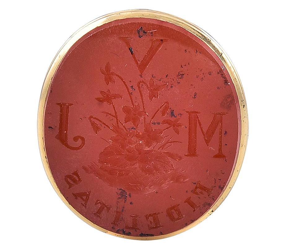 The support, of spindle design to an ornately embossed frame and the Carnelian Intaglio is romantically engraved with wild violets and the initials VLM and the word FIDELITAS (Fedelity) This Seal comes with its original fitted case, only the second