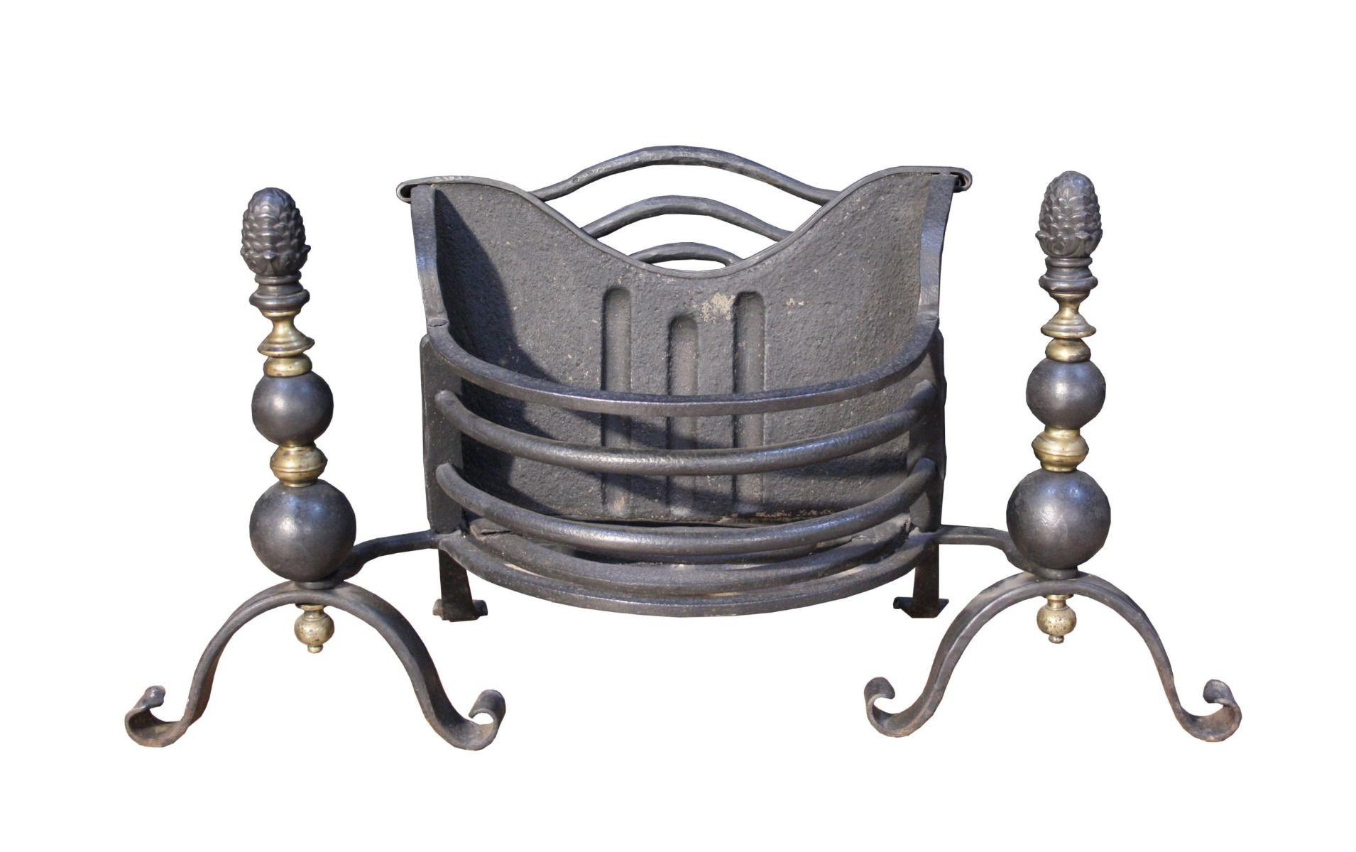 An antique Victorian wrought iron fire grate. Incorporating English brass, wrought and cast iron, this fire grate is finished in black graphite polish.
It showcases polished brass finials on tapered legs and a shaped cast iron back, with a shaped
