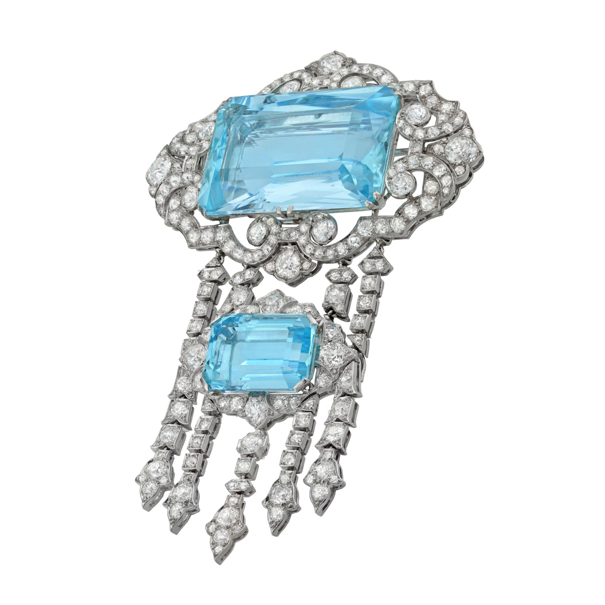 An impressive aquamarine and diamond brooch by Hennell, the rectangular radiant-cut aquamarine weighing 66.02 carats, within a diamond-set lozenge-shaped frame of scroll design with four diamond-set linear drops, suspending a smaller cluster of