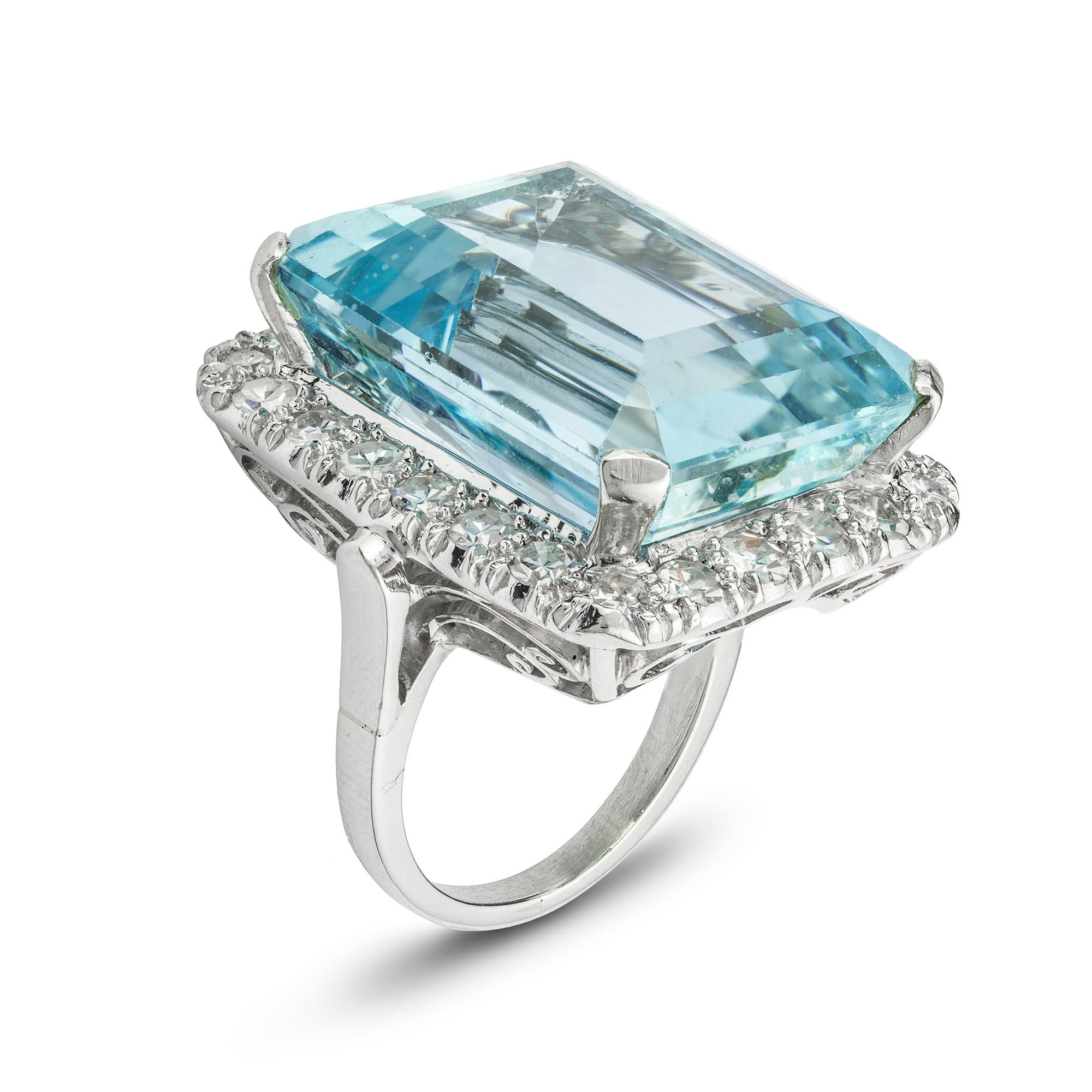 An aquamarine and diamond dress ring, the emerald-cut aquamarine measuring approximately 20.5 x 16 x 11.1mm and weighing 27.2 carats, surrounded by single-cut diamonds estimated to weigh 1.3 carats in total, all claw set to a platinum mount with