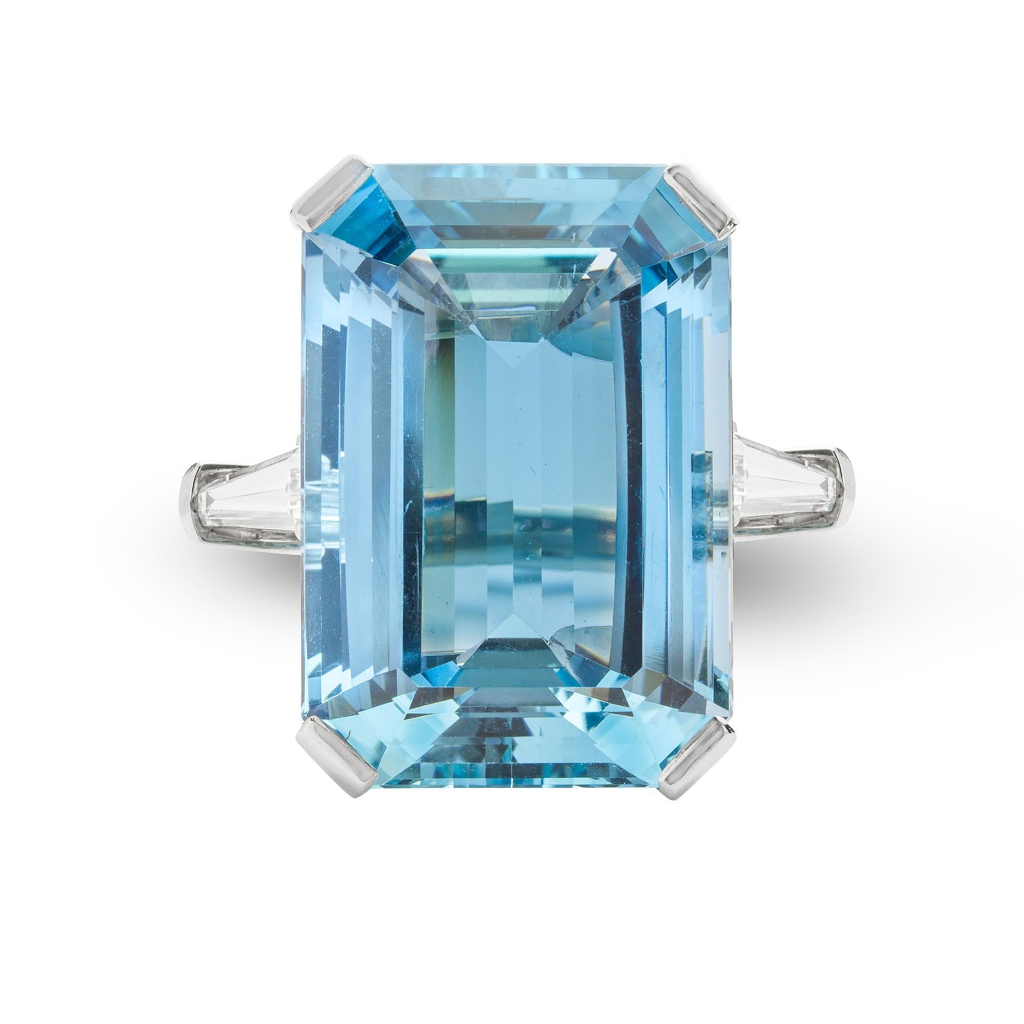An aquamarine and diamond ring, the emerald-cut aquamarine weighing 43.9 carats four claw set to a platinum mount with tapering baguette-cut diamond set to each shoulder weighing 1.32 carats in total, to tapering D-section shank, made by Bentley and