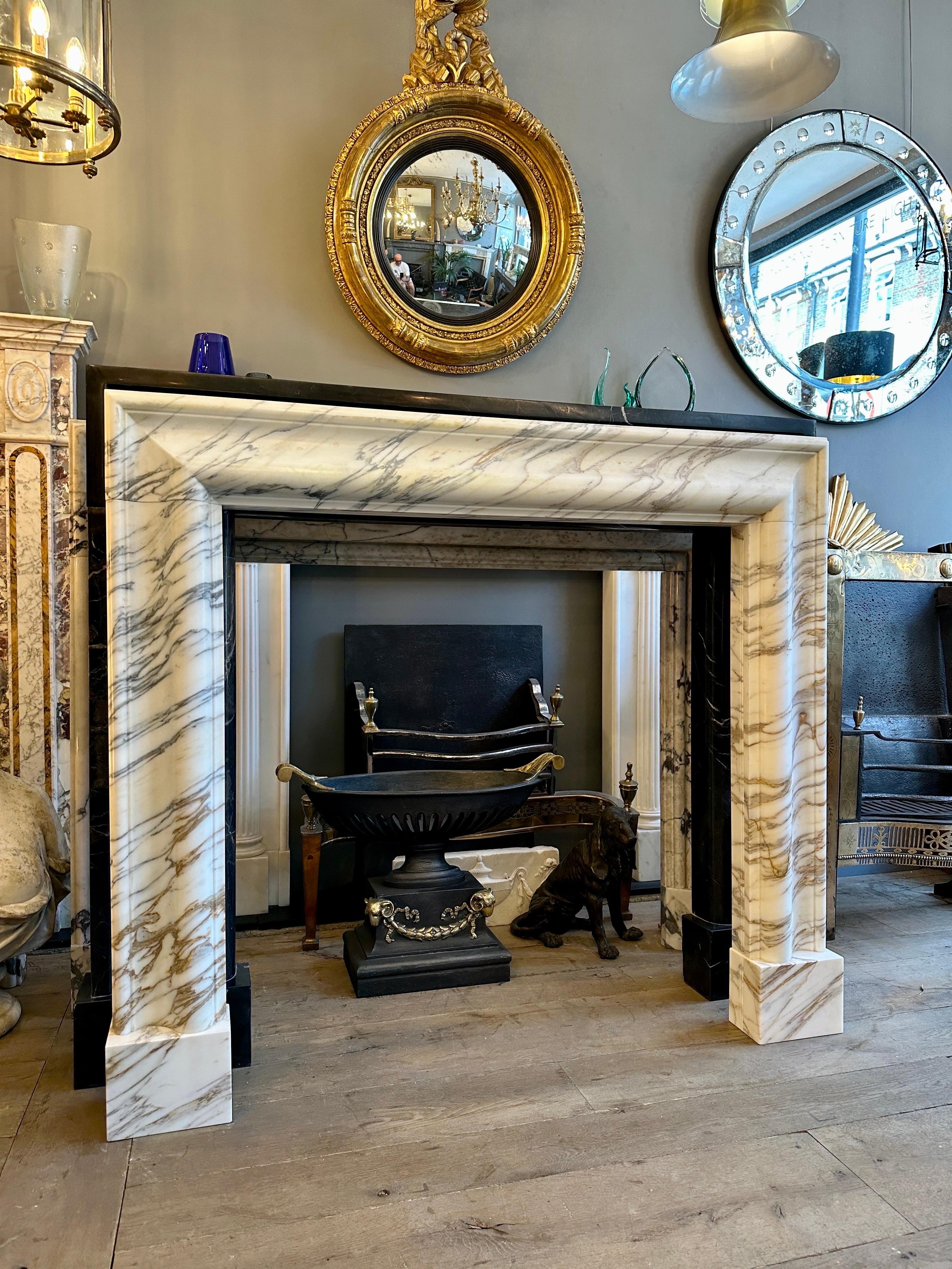 A well proportioned Bolection fireplace surround in Italian Arabescato Corchia marble. The warm variegated colours of the veining showing nicely from the pale creamy background colour. The inner and outer of the frame with lined  ribbed moulding,