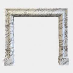 An Arabescato Marble Bolection Fireplace Mantle