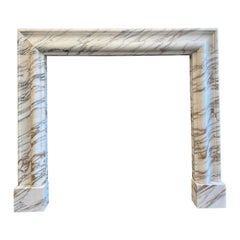 An Arabescato Marble Bolection Fireplace Mantle