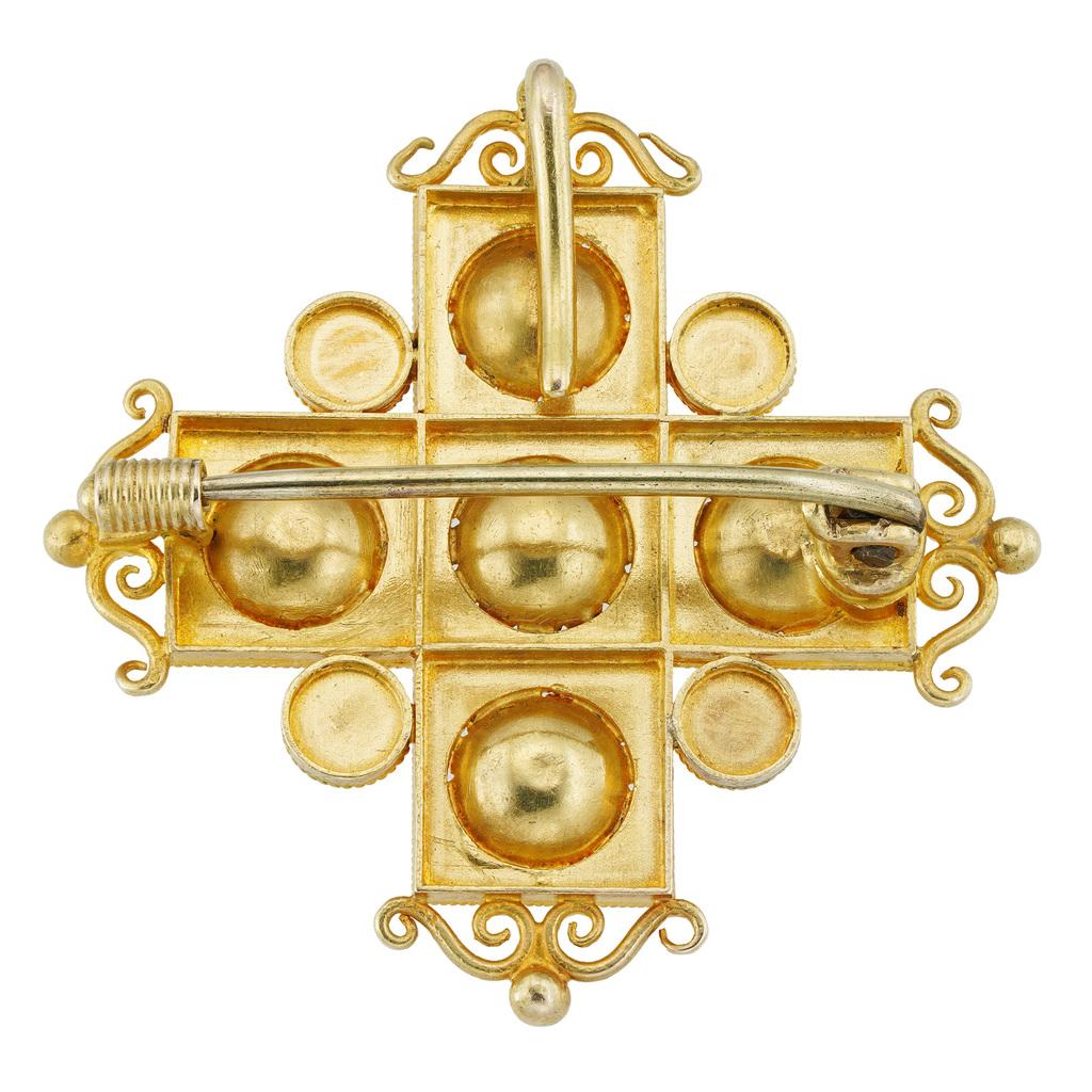 An archaeological revival gold cross brooch/pendant, consisted of five square panels, each with a concave rosette, the central one set with a square-cut ruby, the other four set with a square-cut emerald, with granulation and wire-work decorations,