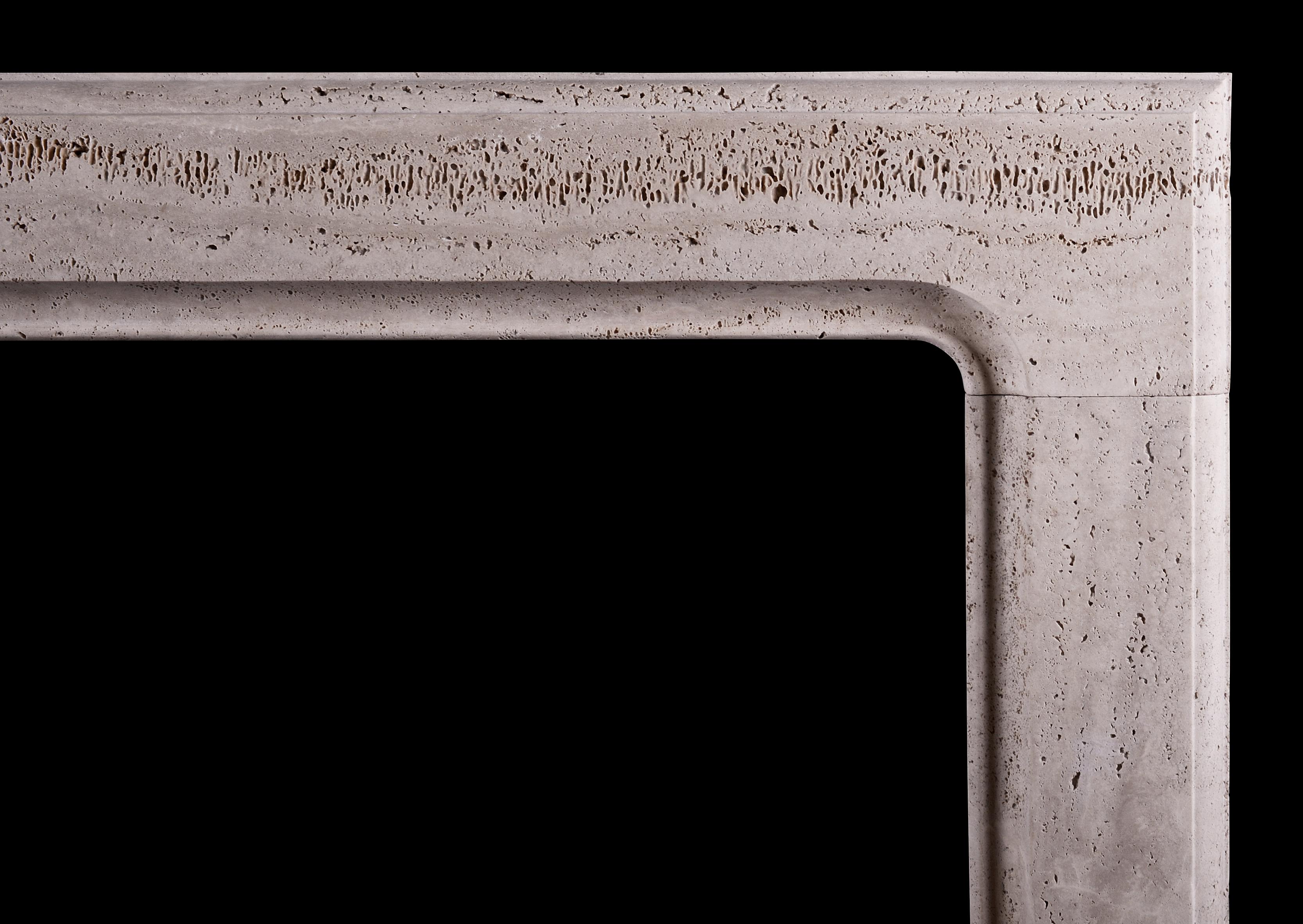 An architectural bolection fireplace of small scale with moulded frieze and jambs. Made in a rustic Italian travertine stone, currently unfilled. English, modern.

NB. May be subject to an extended lead time, please enquire for more info.