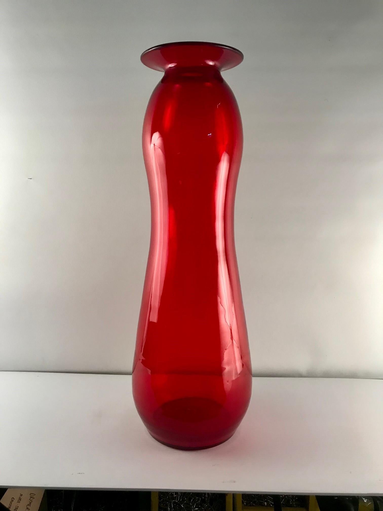 This gourd-shaped vase is in a very striking red colour, a vibrant and shining red , in a very elongated form. Acquired from a private collection, this vase was among several high quality examples and attributed to Blenko . At 26inches, it has a
