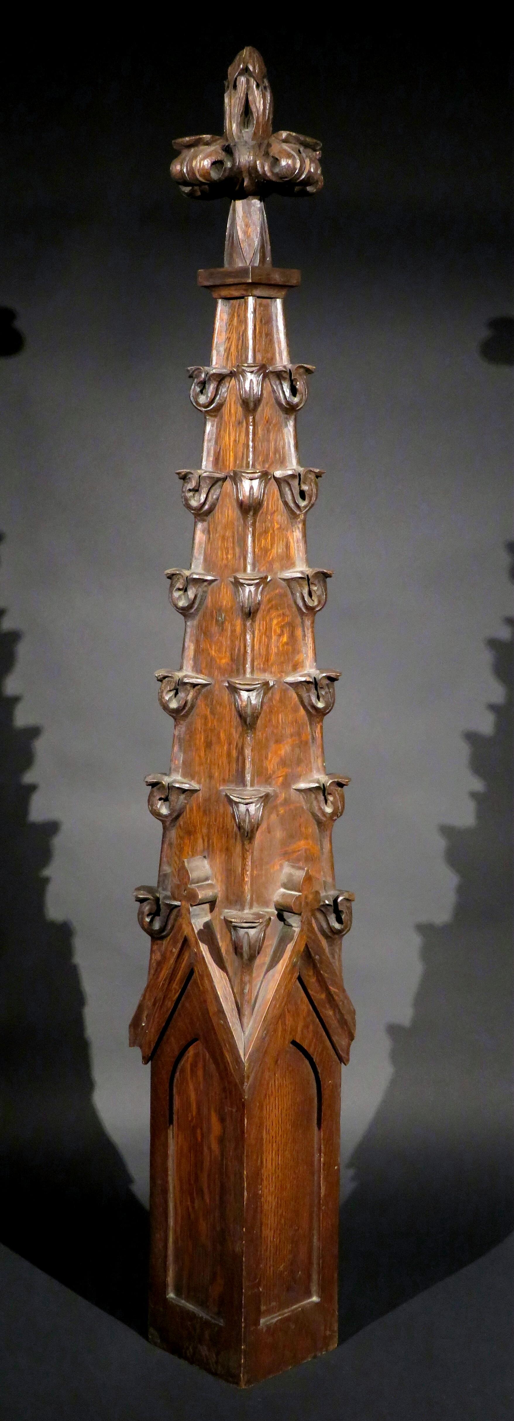 Une maquette architecturale impressionnante et bien détaillée d'un transept-spire ou pinacle d'inspiration gothique en chêne, lambrissé sur quatre côtés et décoré de crochets sculptés à la main, s'élevant jusqu'à une croix avec des motifs de