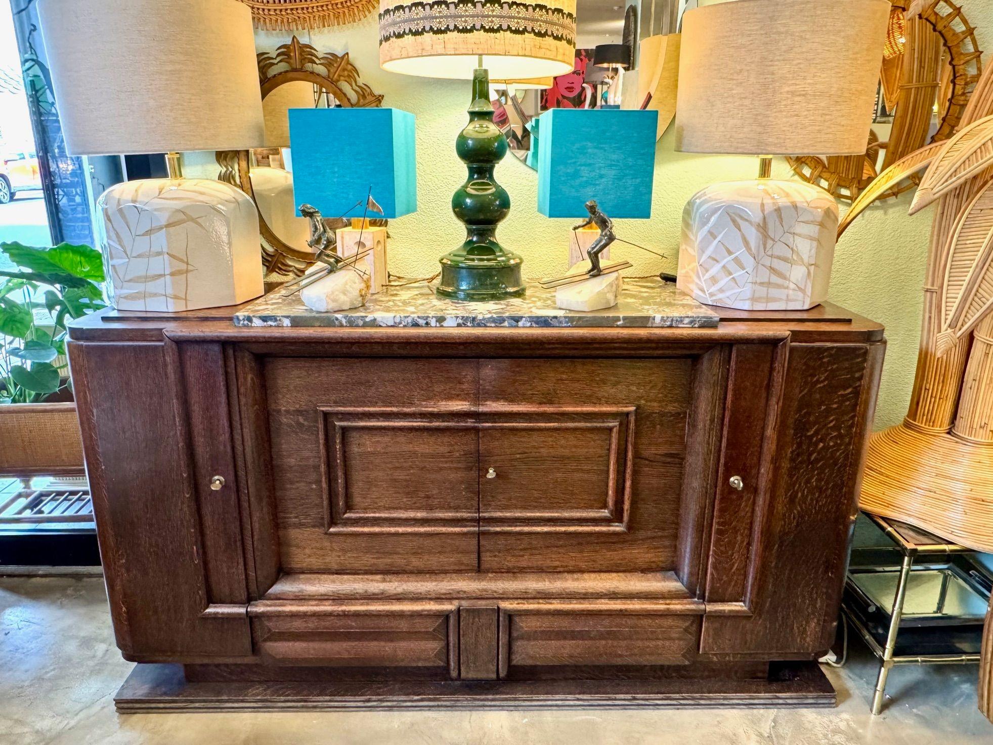 Buffet en chêne Art Déco français des années 1940 avec plateau en marbre massif d'origine par Gaston Poisson. Avec deux portes latérales pivotantes qui révèlent trois étagères incurvées, chacune avec une belle bordure en marqueterie. L'armoire
