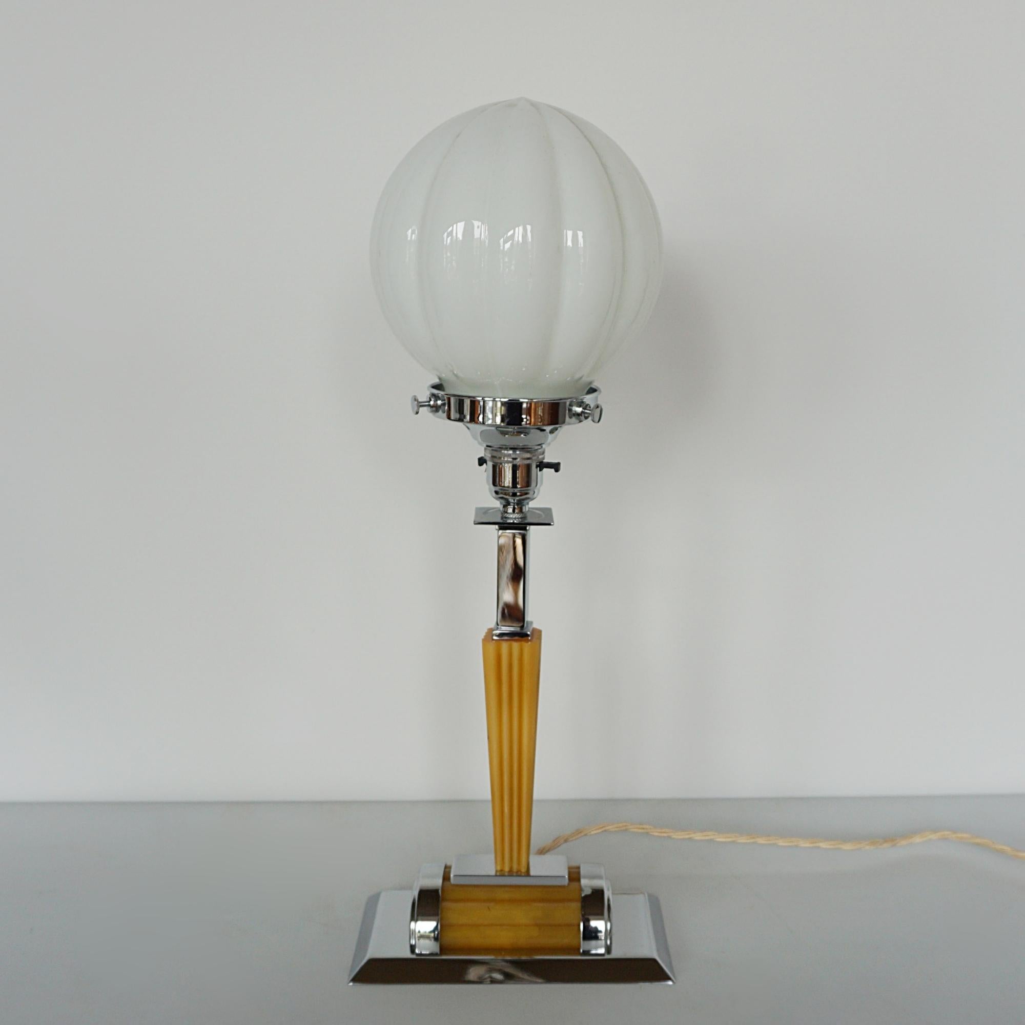 An Art Deco table lamp. Tapered amber bakelite set over a rectangular base with a segmental white globe. 

Dimensions: H 45cm W 18cm D 9cm 

Origin: English 

Item Number: J336

All of our lighting is fully refurbished, re-wired, and re-chromed with