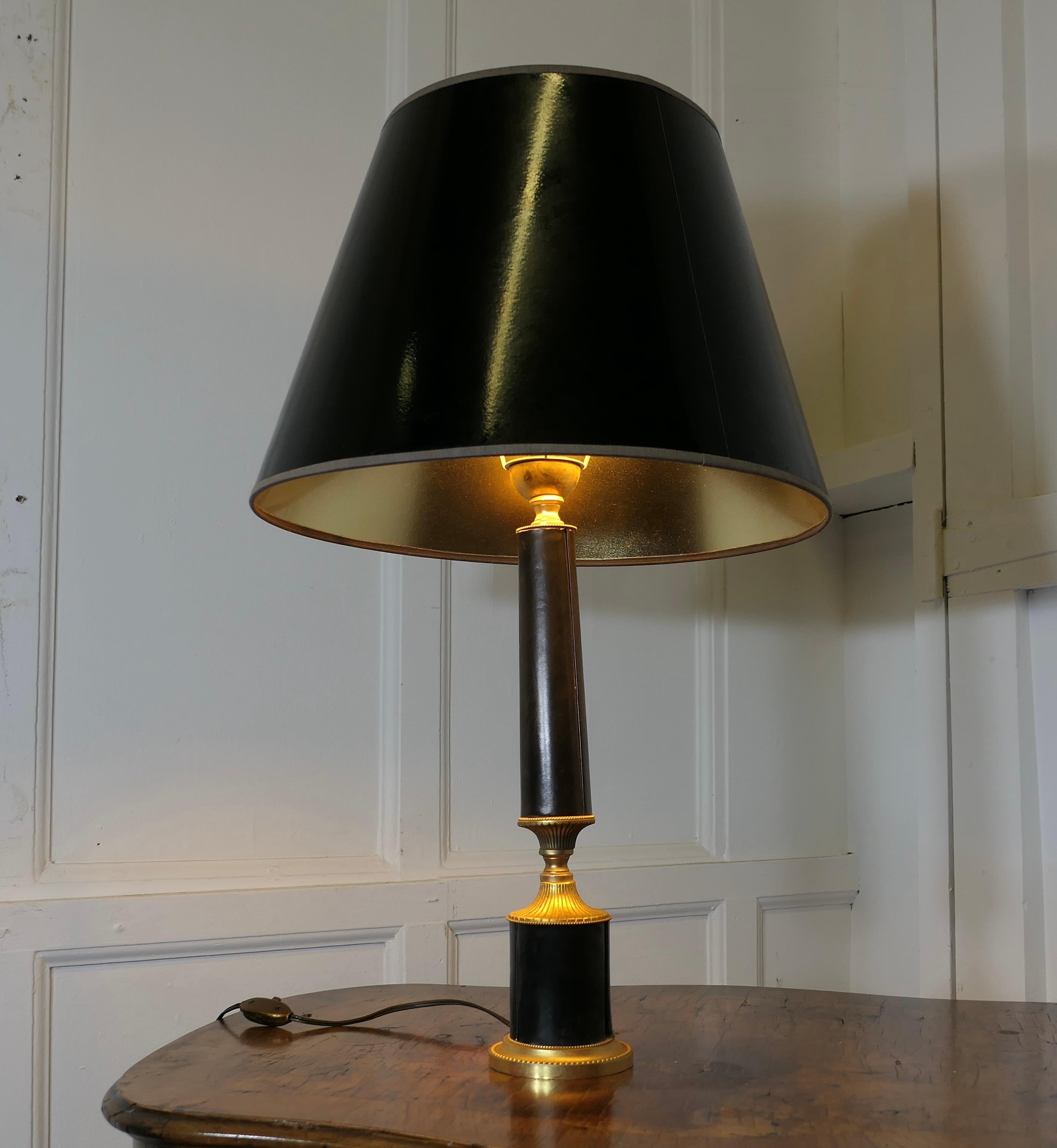 Lampe de table Art déco en laiton et cuir noir 

Cette lampe est très élégante, elle est fabriquée en laiton et recouverte de cuir noir souple, elle a été assortie à un abat-jour noir dont l'intérieur est doré pour compléter les tons de la lampe
La