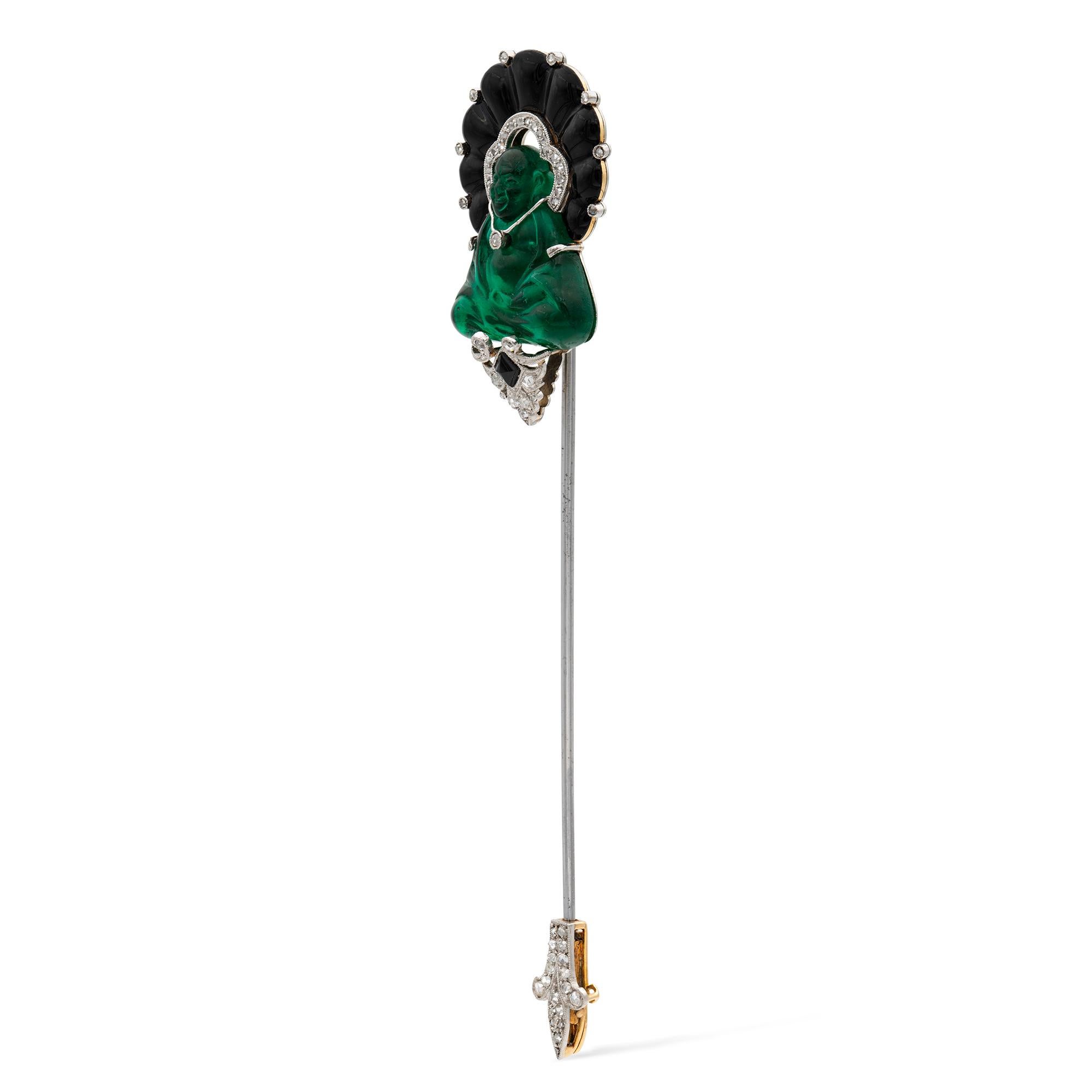 An Art Deco Buddha sureté pin by Ghiso, the pin set with a fine green pâte de verre Buddha, resting upon an onyx and rose-cut diamond cluster pedestal, and surmounted with a black enamel and rose-cut diamond crown, all to a platinum and yellow gold