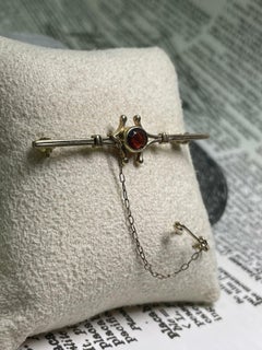 An Art-Deco c1930's Garnet (0.60ct) & 9K Gold Bar Brooch, with security chain.