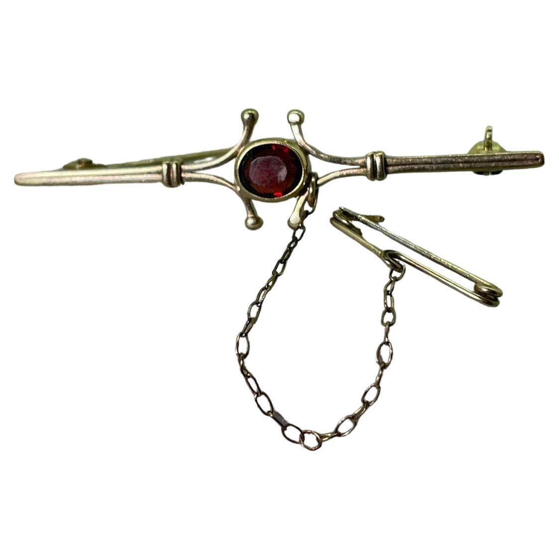 An Art-Deco c1930's Garnet (0.60ct) & 9K Gold Bar Brooch, with security chain. For Sale