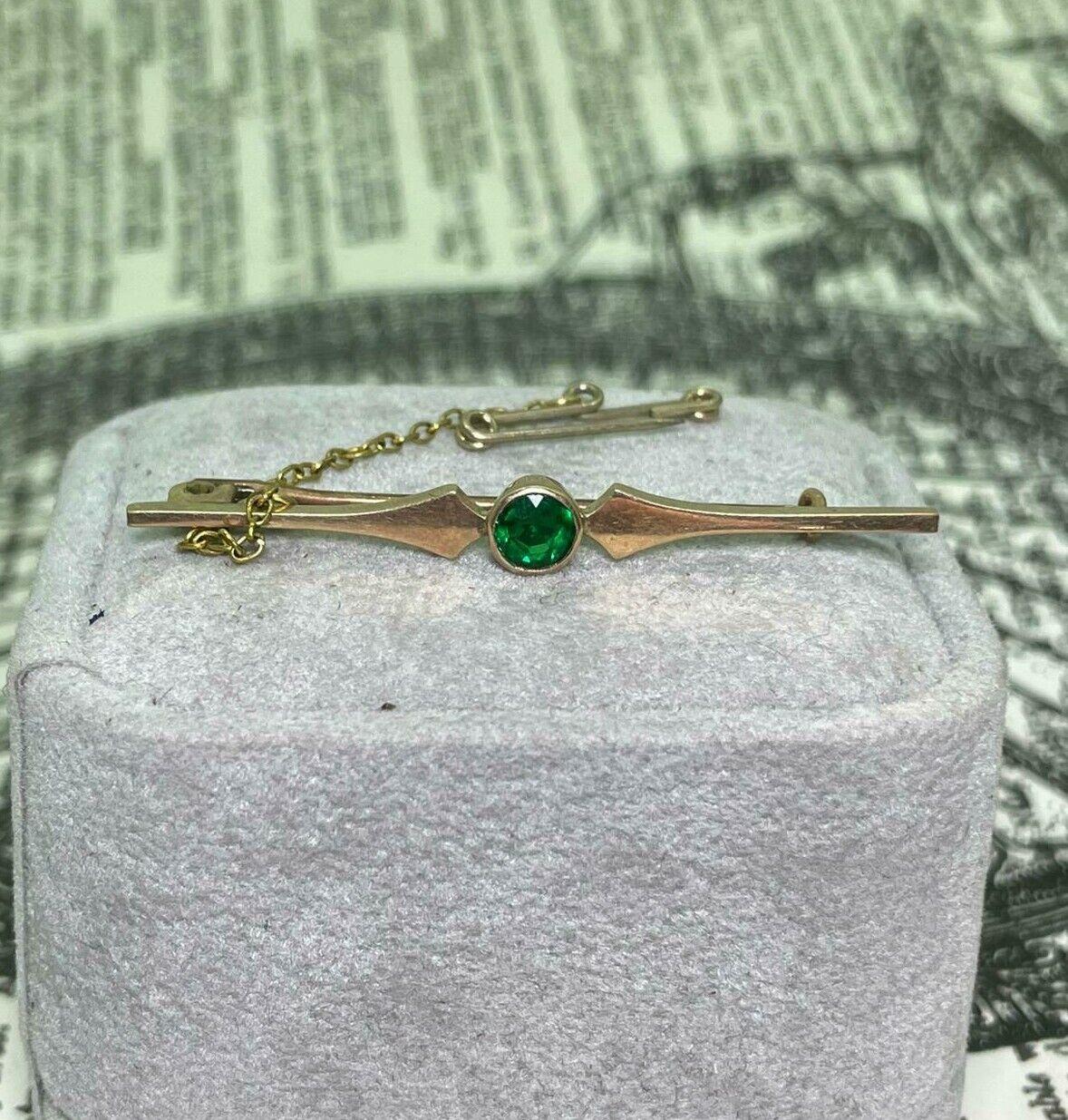 Beautifully crafted in 9K Gold (stamped 9ct)
this stunning Bar Brooch 
is of timeless & classic design
dating from Art-Deco (c1930's) period
 
It centers a bezel set Gilson Synthetic Emerald
of gorgeous vibrant green colour
set within simple