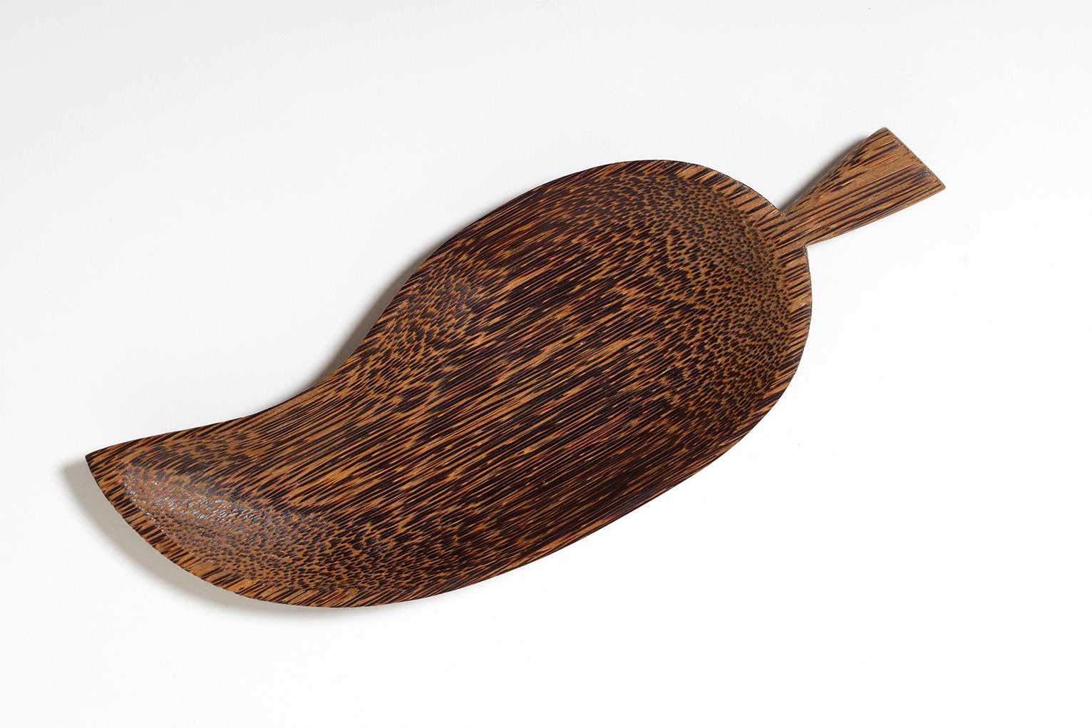 An Art Deco carved solid palmwood bowl, in a leaf shape
France, 1940s.