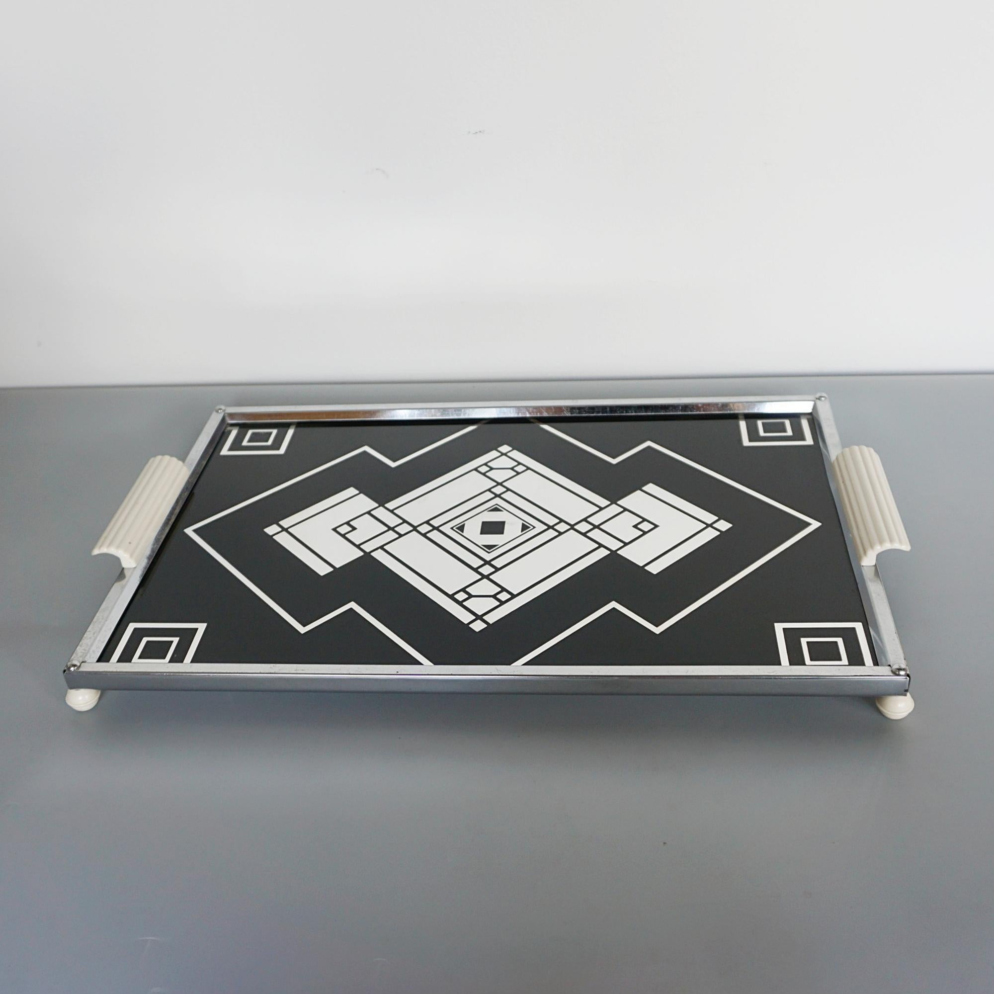 An Art Deco serving tray. Original Bakelite handles, signed to underside. 

Dimensions: H 2cm W 41cm D 22cm

Origin: English

Date: Circa 1930

Item Number: 2108246