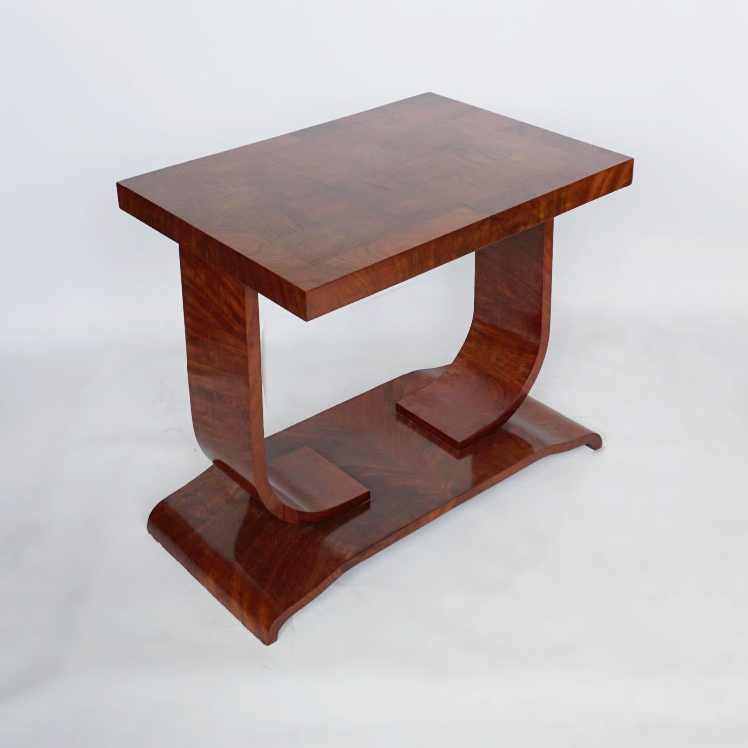 An Art Deco coffee/side table. Contrasting figured walnut grain creating a chequered effect to table top. Set over a U-shaped base. Figured walnut throughout. 

Dimensions: H 65cm W 70cm D 50cm

Origin: English

Date: Circa 1930

Item