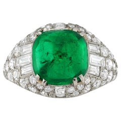 An Art Deco Colombian emerald and diamond bombé ring