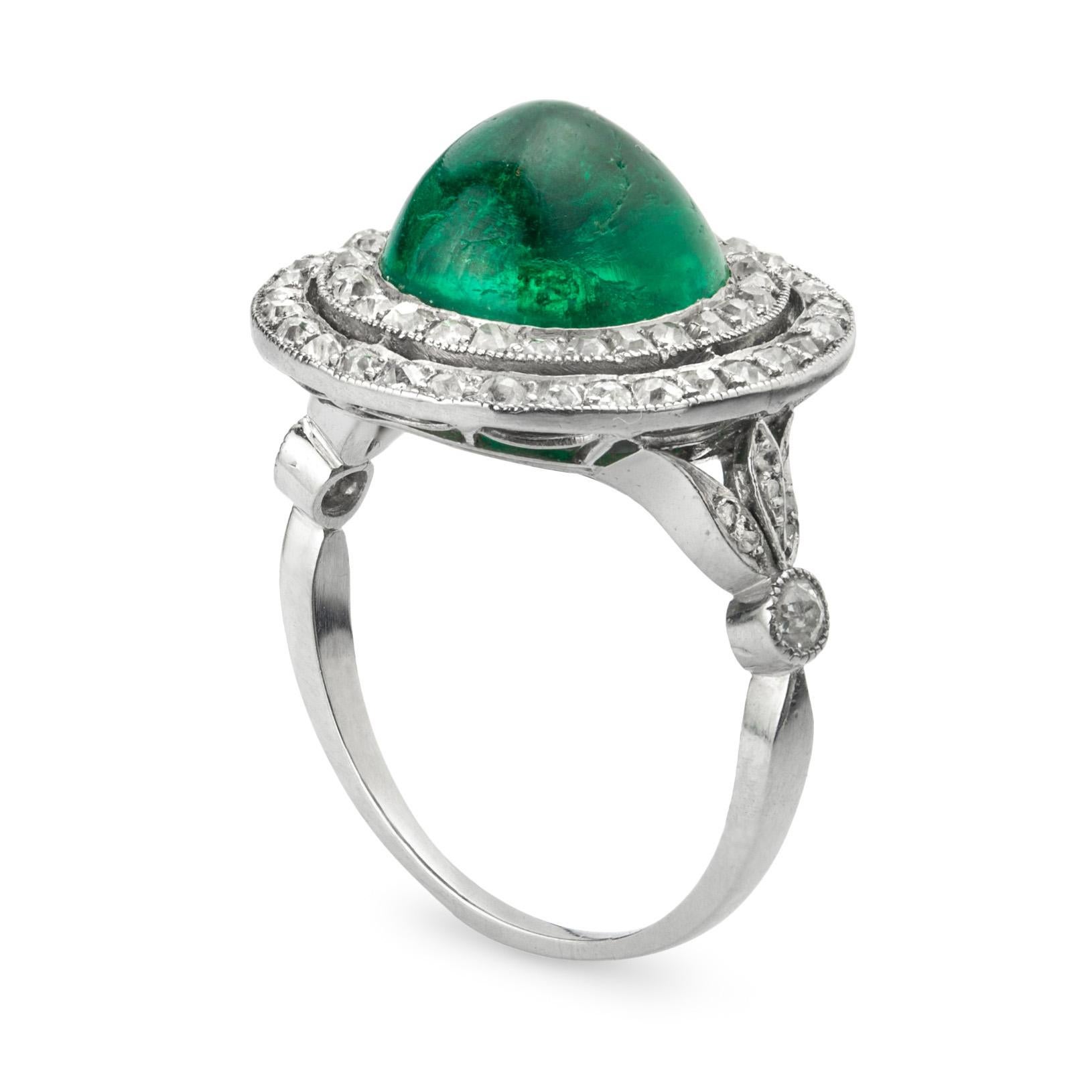 An Art Deco cabochon emerald and diamond cluster ring, the oval cabochon-cut emerald estimated to weigh 4,0 carats, accompanied by The Gem & Pearl Lab. Report stating that is of Colombian origin, set to the centre of a double cluster of sixty round