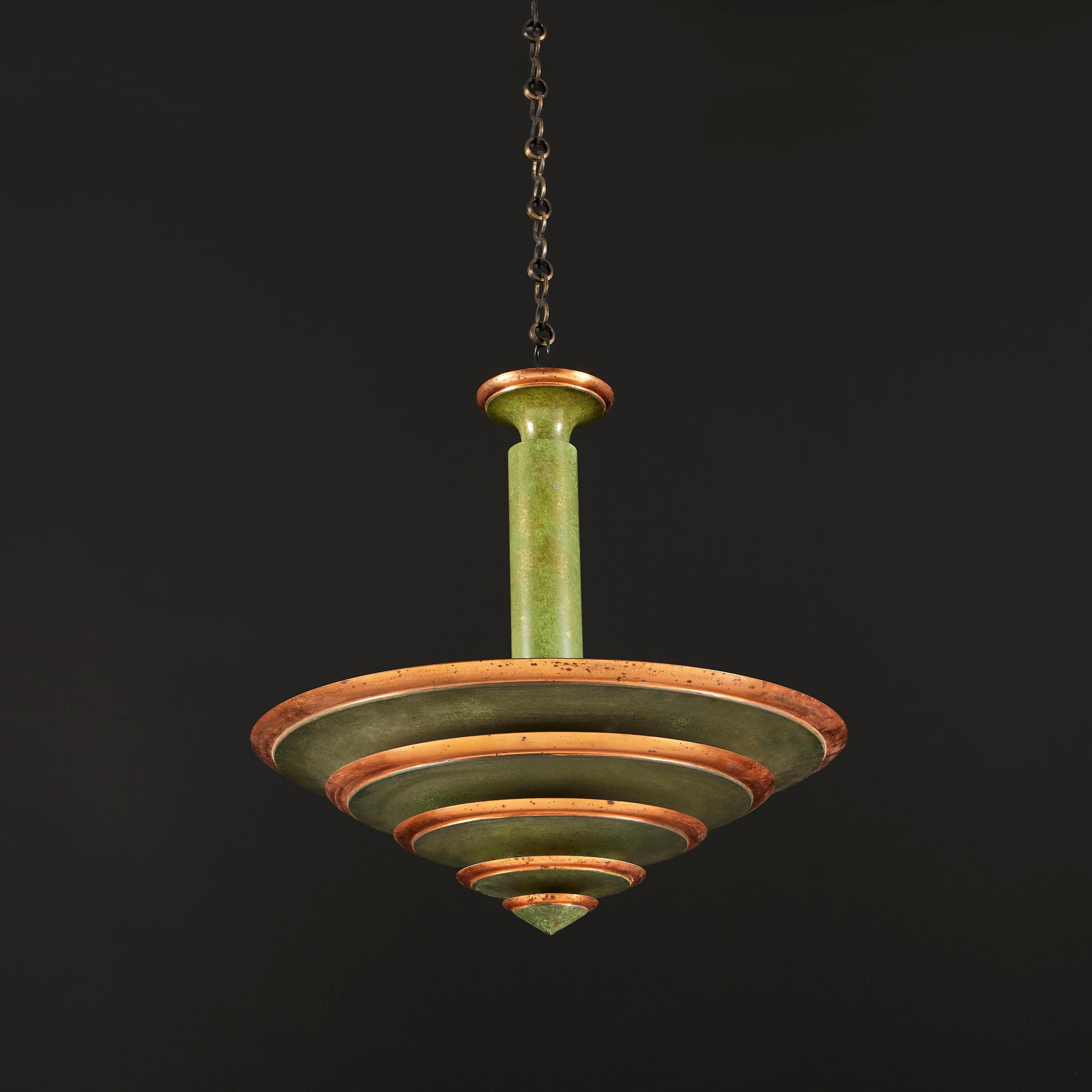 An unusual art deco copper hanging dish light, composed of four dishes stacked to form a conical shape, each layer with verdigris bands and copper contrasting rims.

Currently wired for the UK. Chain available upon request; please contact us for