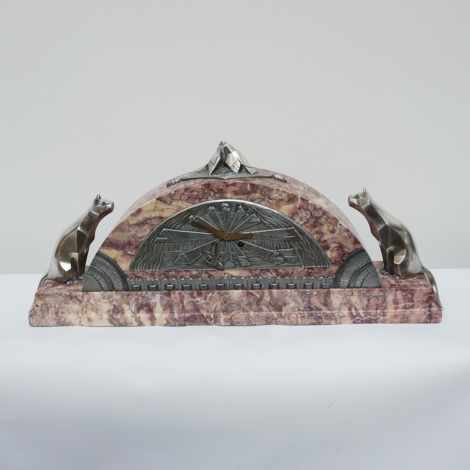 An Art Deco cubist clock attributed to Georges Lavroff. Pink marble and silvered bronze with original garnitures. Two silvered bronze love birds with cubist silvered bronze cats to either side, stylised Art Deco clock dial. Eight day movement, half