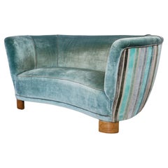 An Art Deco Curved Sofa Upholstered in Velvet